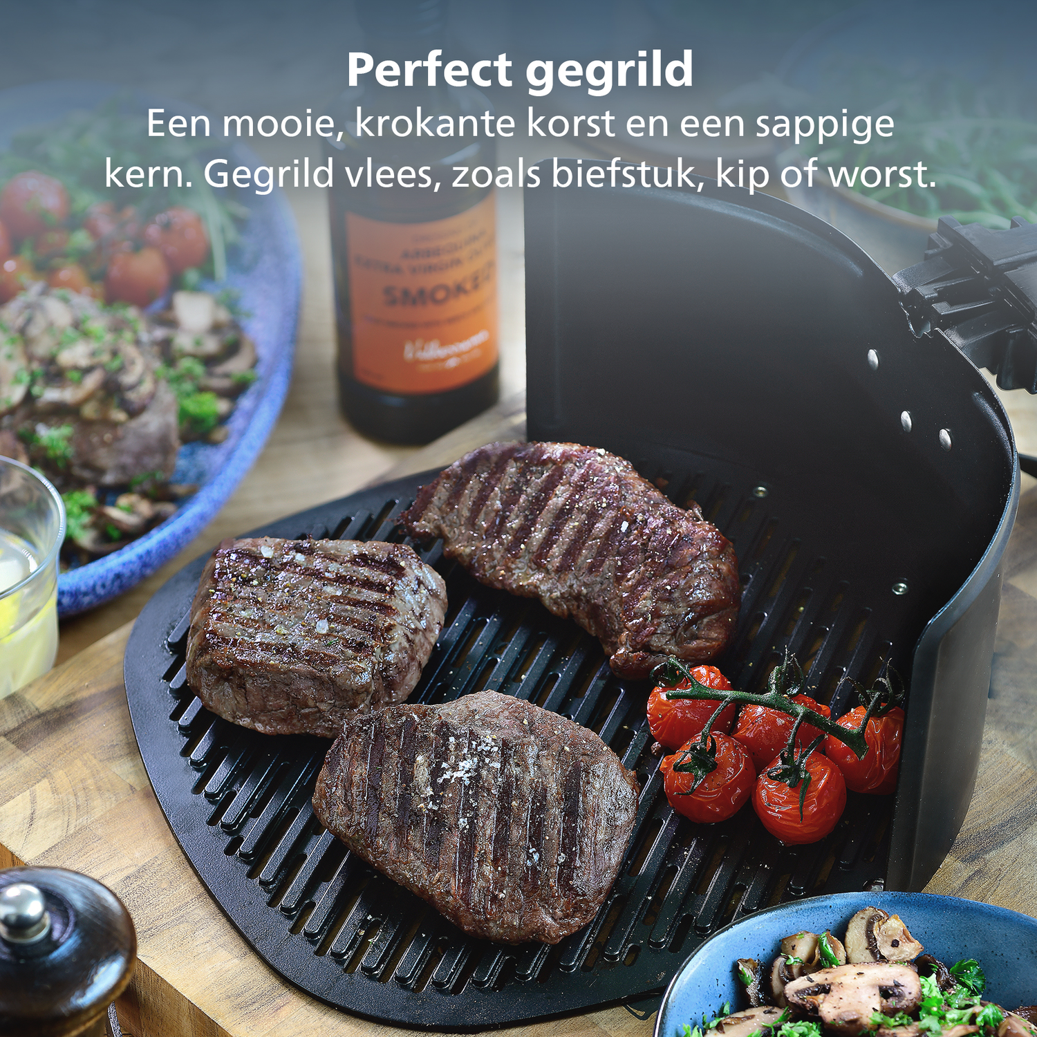 Gegrilde steaks met tomaten op een grill. Er is een fles saus en een bijgerecht met champignons. Houten tafel.