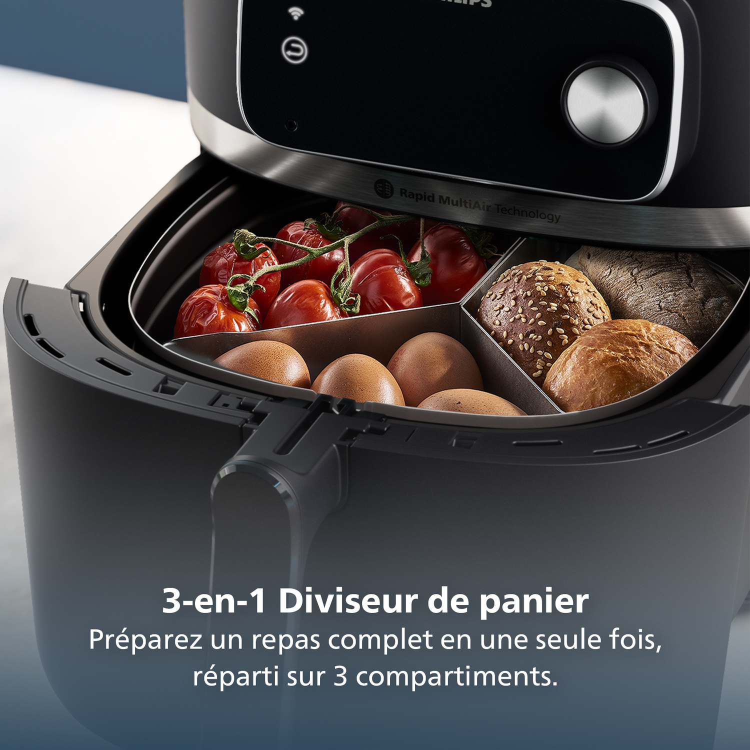 An air fryer with three compartments, containing tomatoes, eggs, and bread. The fryer is black, with a digital display and a knob.