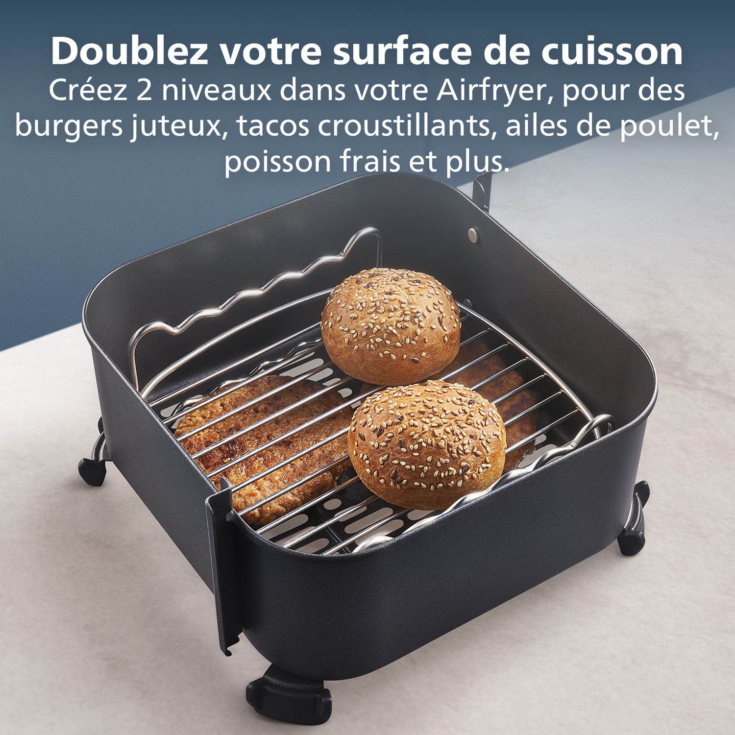 Een airfryer met twee hamburgerbroodjes en burgers op het rek, ter promotie van de kookruimte. Franse tekst bovenaan.