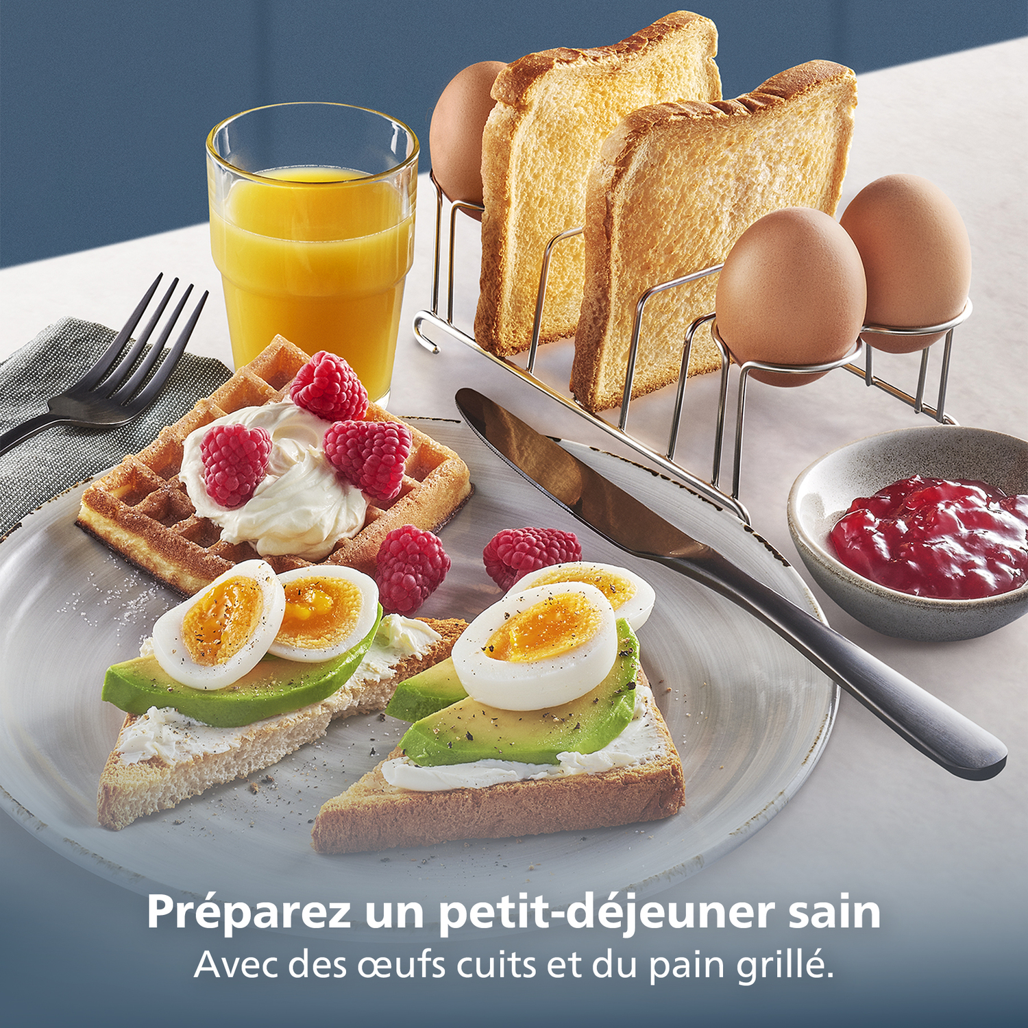 Ontbijt met wafels, toast, eieren, avocado en jam. Sinaasappelsap in een glas. Frambozen op de wafels.