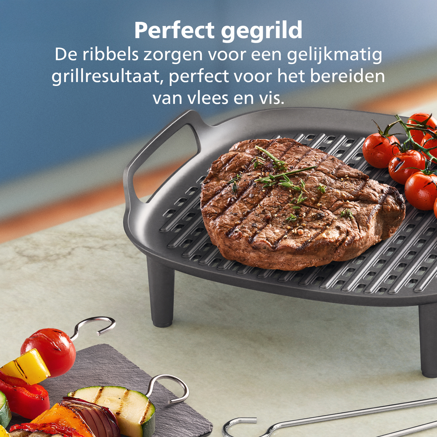 Gegrilde biefstuk op een grillpan met tomaten en groenten. Groenten aan een spies op de voorgrond. Tekst: Perfect gegrild.