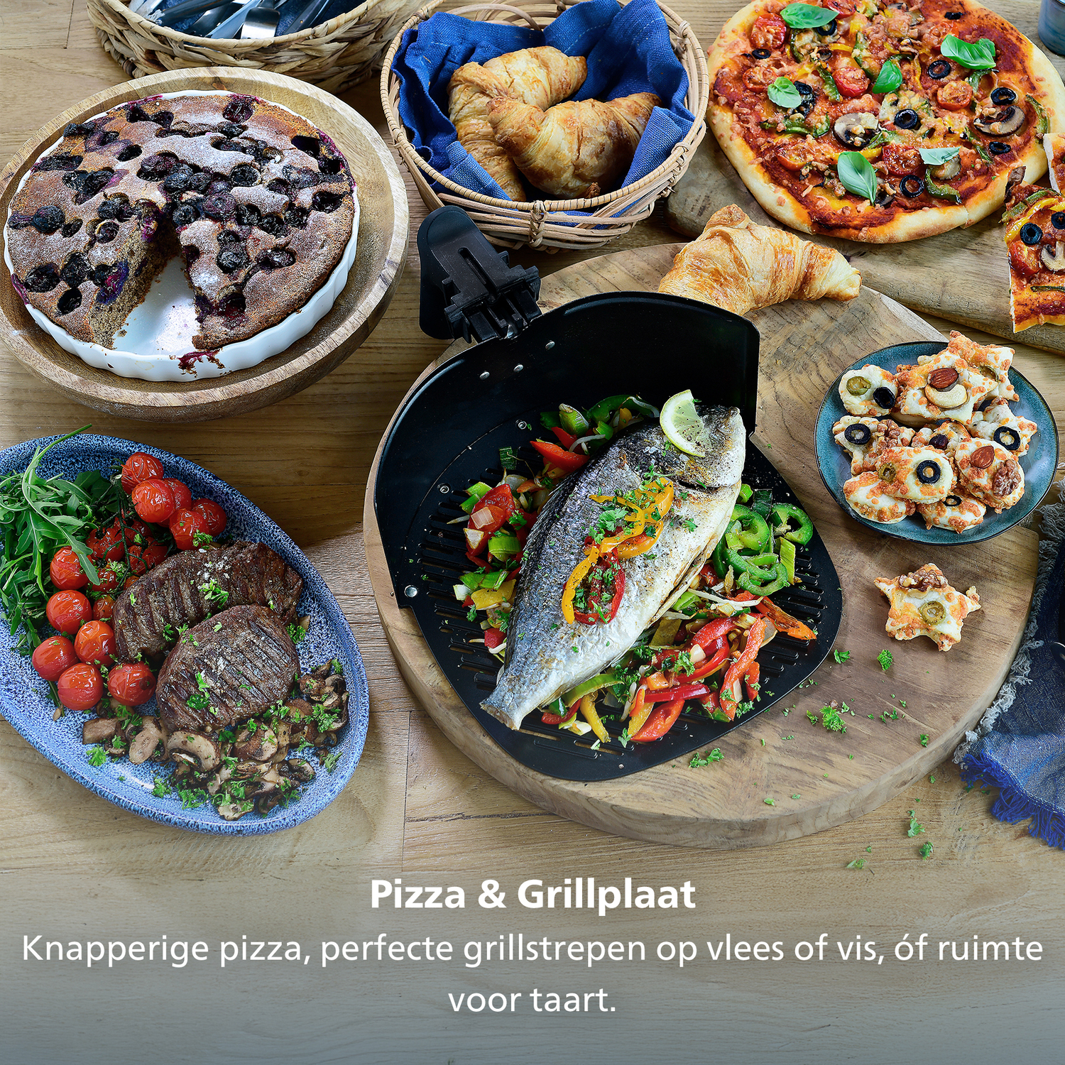 Une table avec une variété d'aliments : pizza, poisson, steak, croissants et une tarte. La nourriture est disposée sur des planches de bois et une assiette bleue.