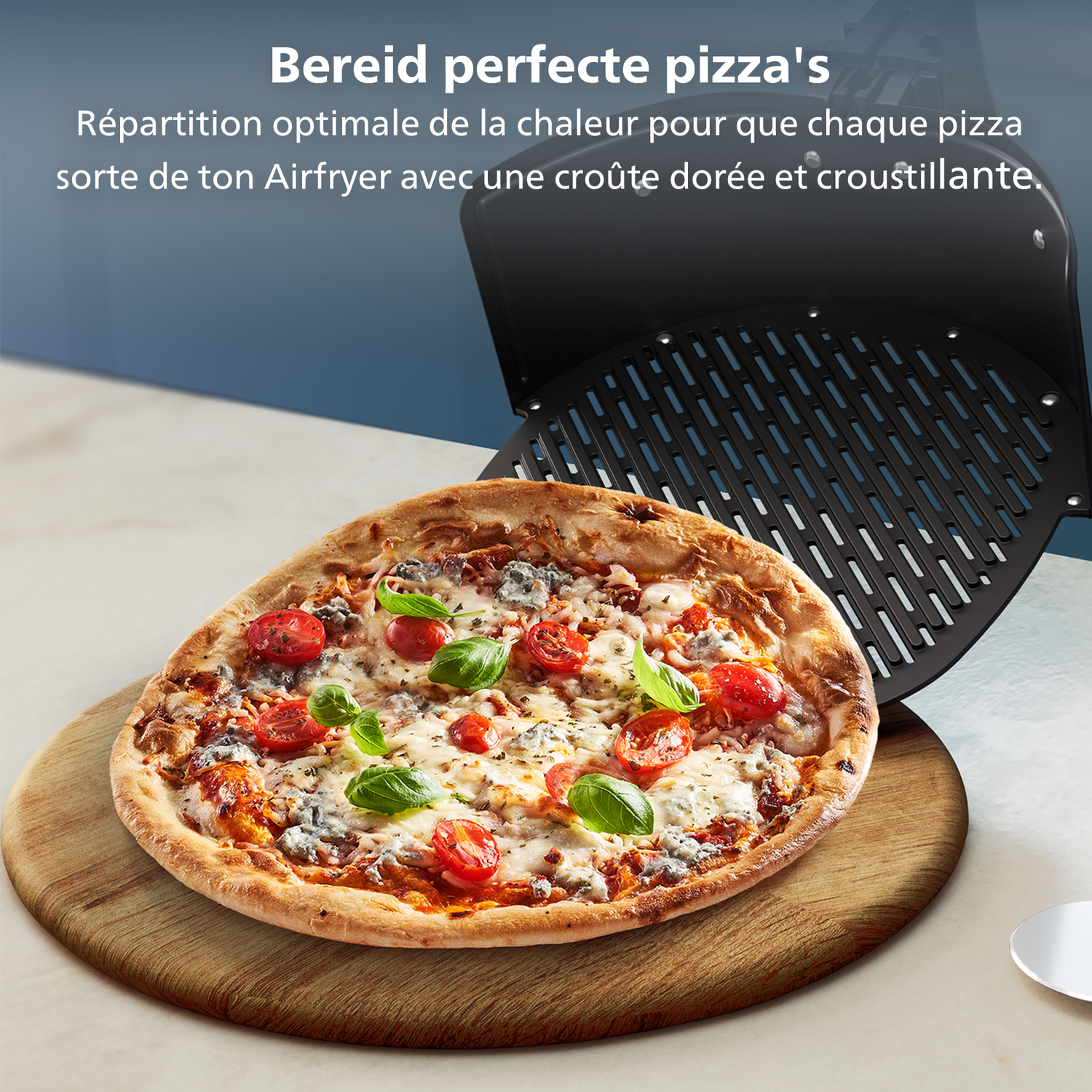 Pizza aux tomates et au basilic sur une planche en bois, à côté d'un plateau de friteuse à air. Texte en néerlandais et français.