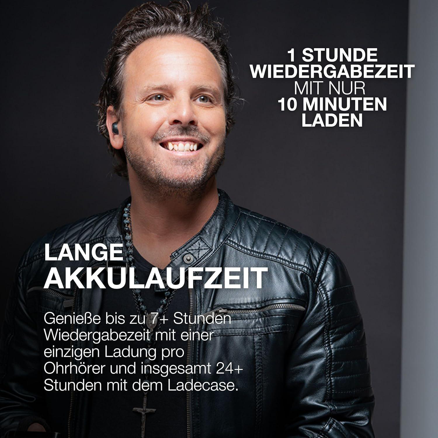 Ein Mann mit Ohrhörern in einer schwarzen Lederjacke lächelt. Text: Lange Akkulaufzeit, 1 Stunde Wiedergabe mit 10 Min Laden.