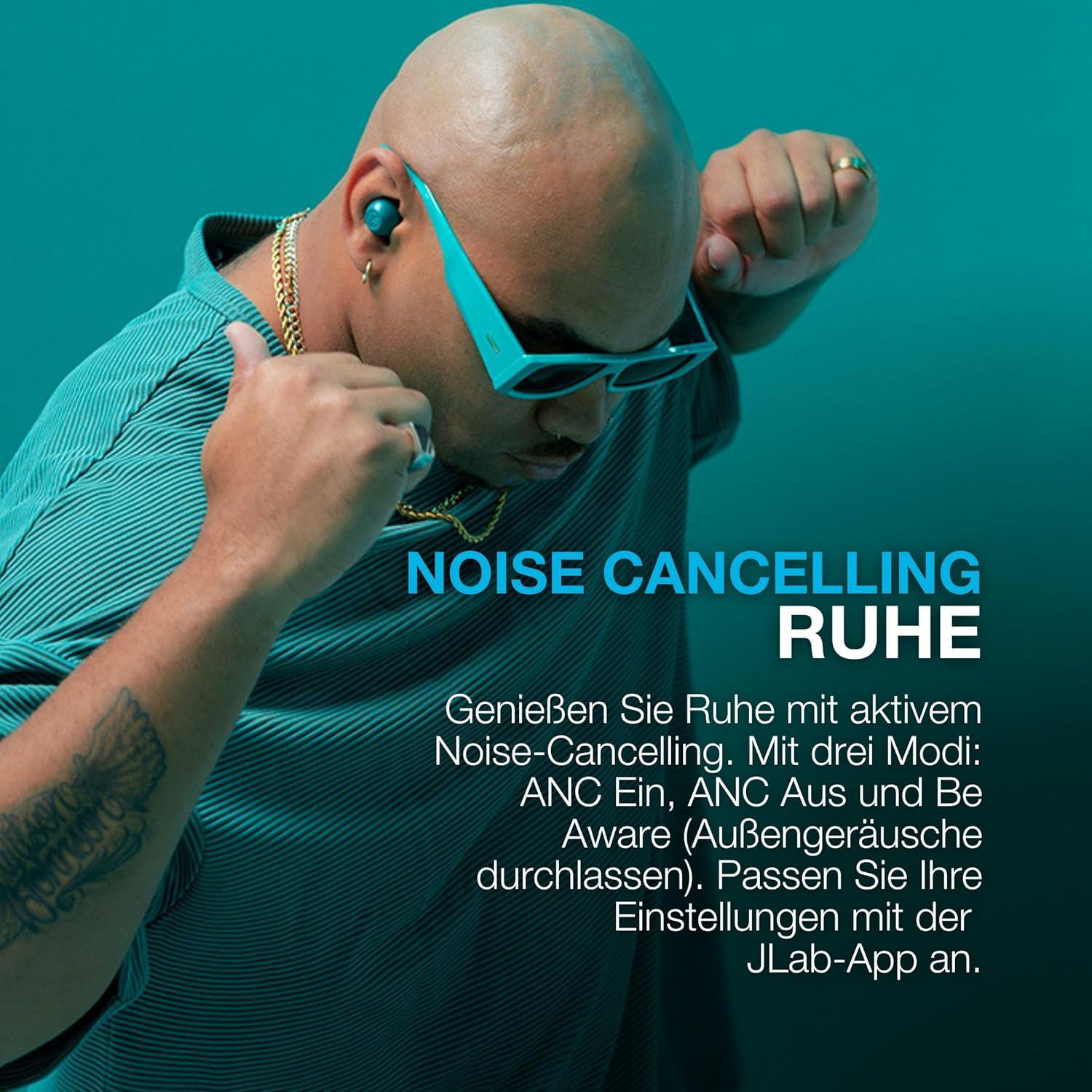 Ein Mann mit Glatze, türkisgrüner Sonnenbrille, Hemd, Goldkette und Ring hört Musik mit Ohrhörern. Text: Geräuschunterdrückung.