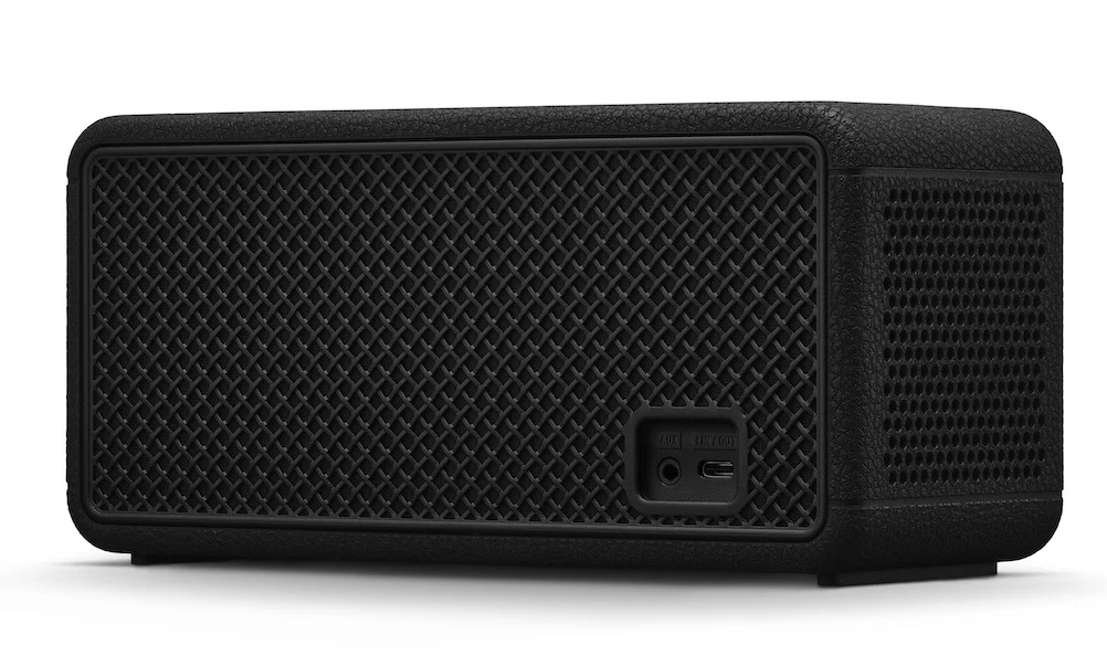 Czarny prostokątny głośnik. Ma siatkowy przód i teksturowane wykończenie imitujące skórę. Z tyłu widoczne są porty.