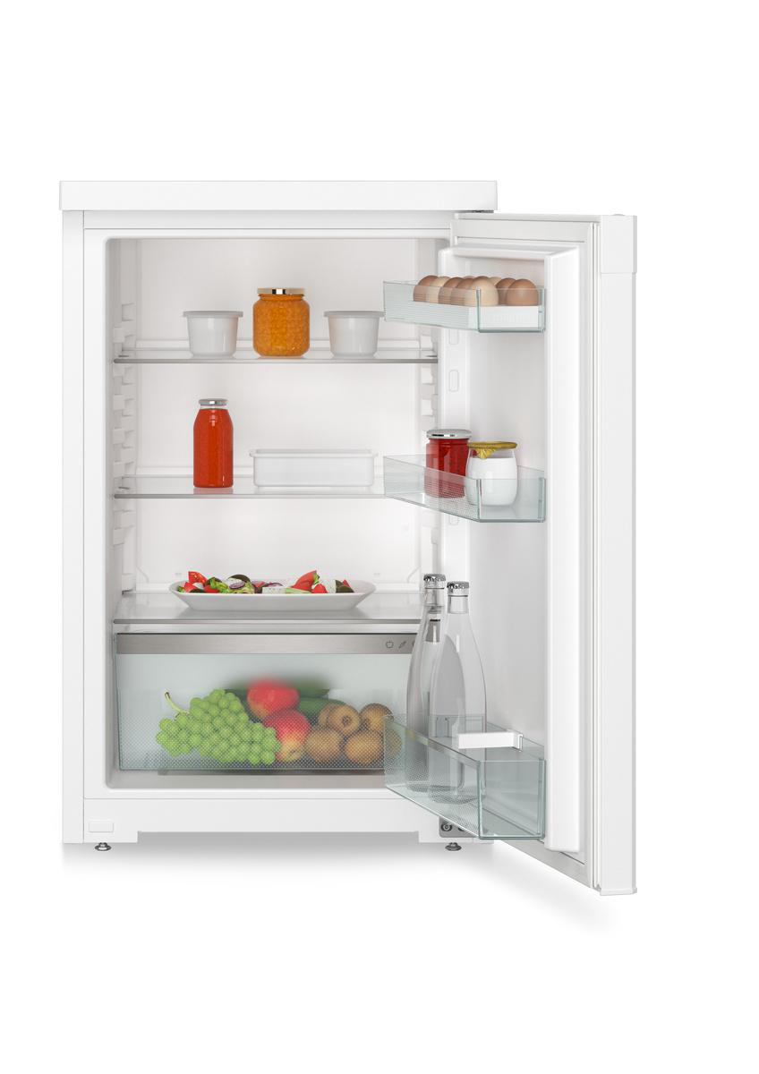 Offener Kühlschrank mit Lebensmitteln: Eier, Gläser, Salat, Früchte und Flaschen. Weißer Kühlschrank mit Glasböden.