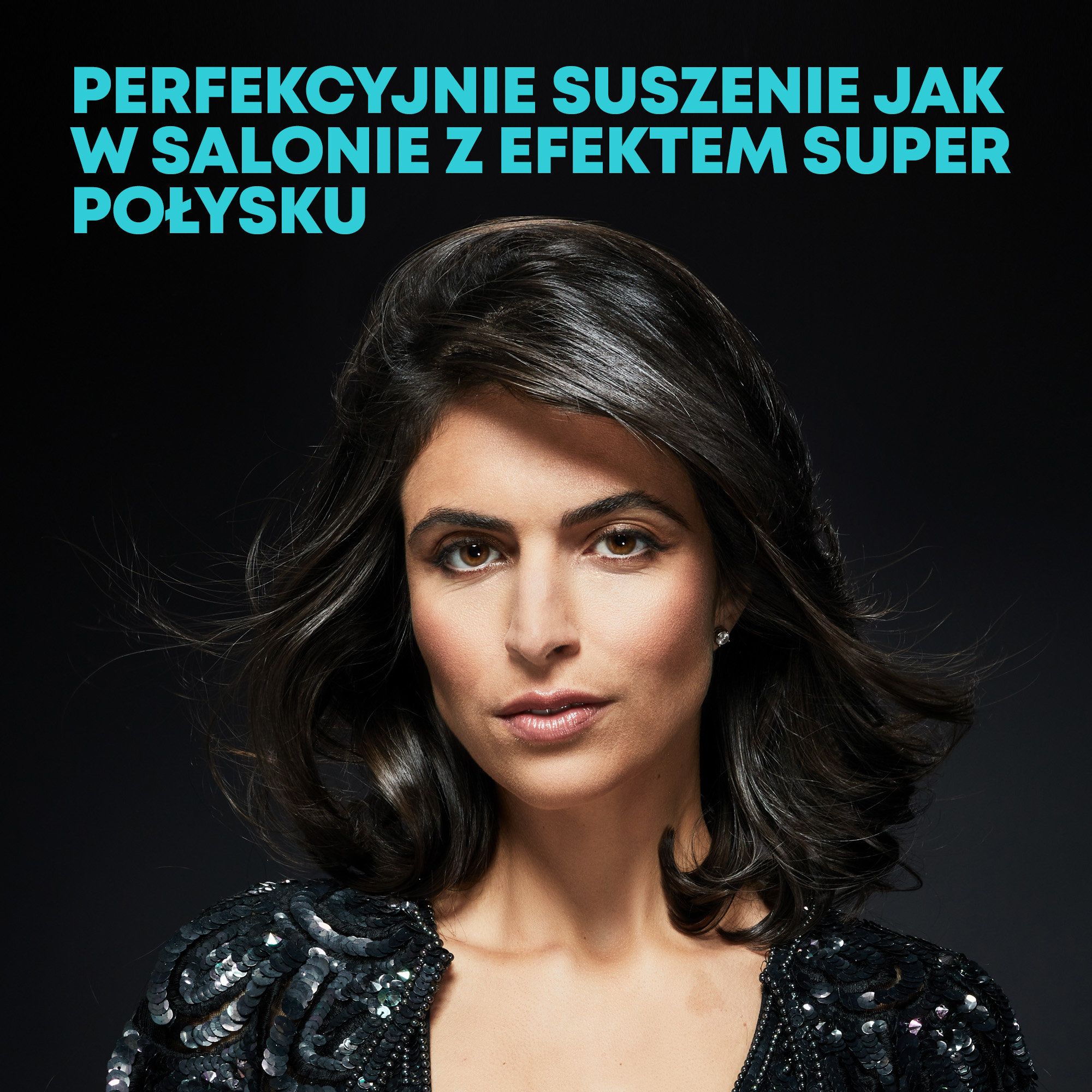 Kobieta z ciemnymi włosami i cekinową kurtką patrzy w kamerę. U góry napis: Idealne suszenie jak w salonie.