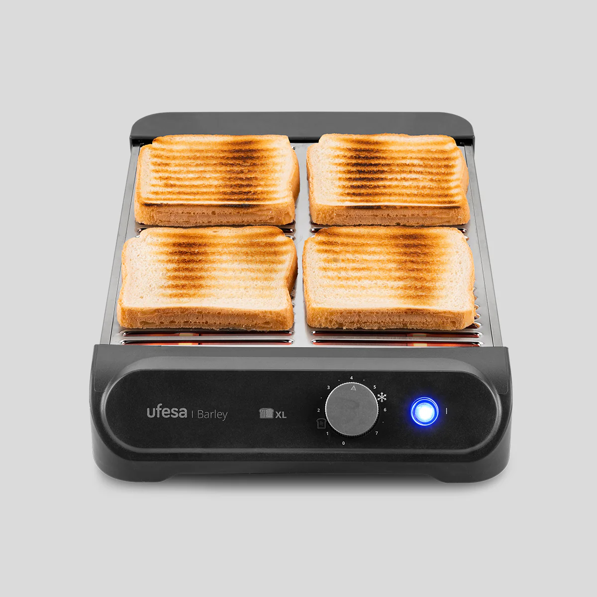 Una tostadora con cuatro rebanadas de pan tostado. Es negra con la parte superior plateada, dial de control y luz azul.