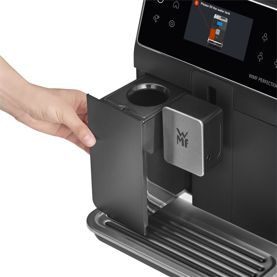 Una mano abre un compartimento negro de la cafetera. La máquina tiene una pantalla con una solicitud para llenar el depósito de agua.