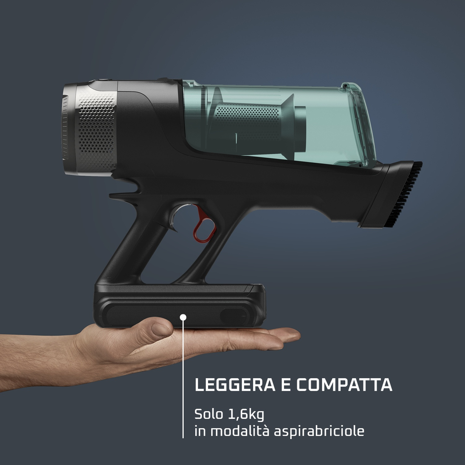 Un aspirapolvere portatile nero e argento è tenuto in una mano. Ha un vano polvere verde trasparente e un grilletto rosso.