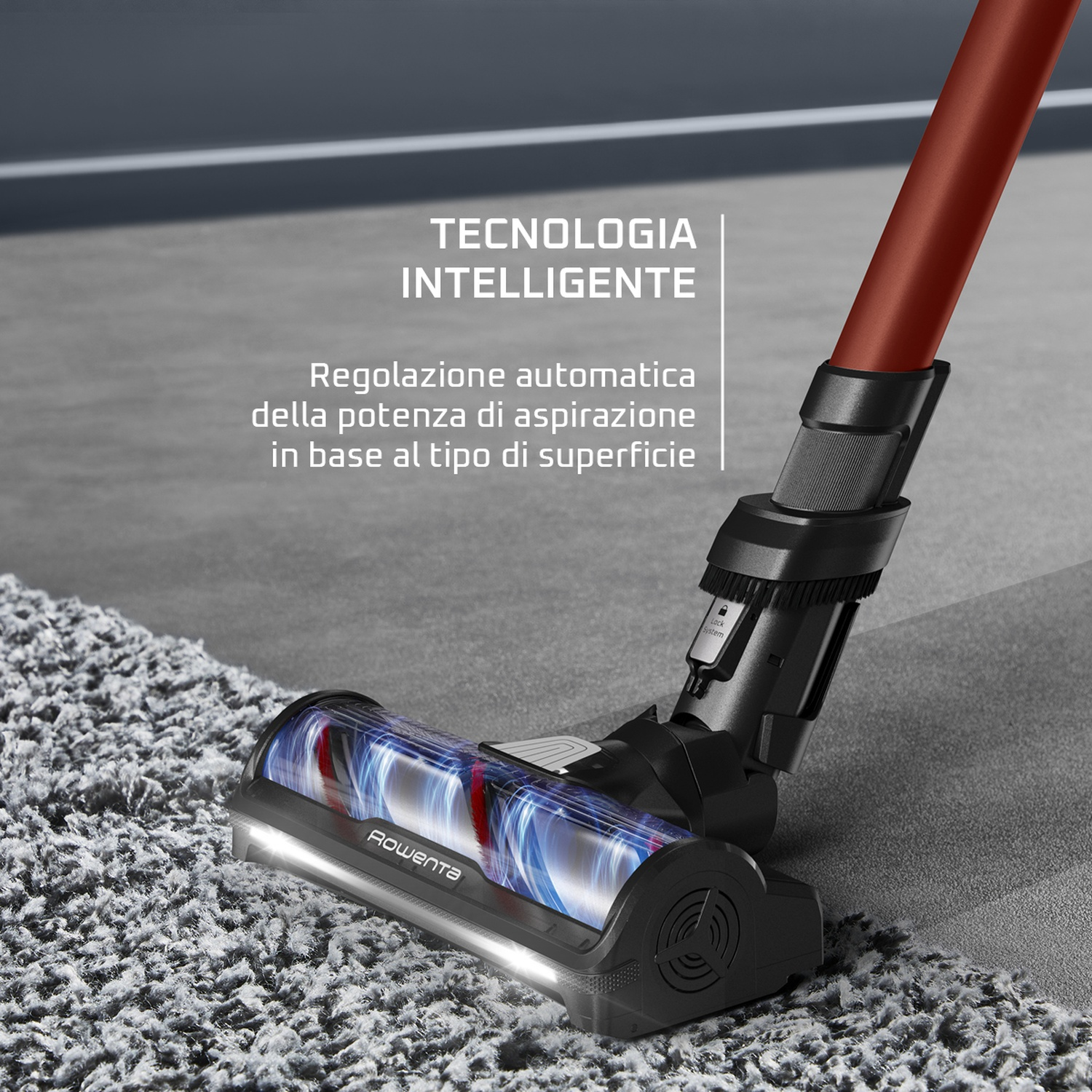 Una testina dell'aspirapolvere pulisce un tappeto grigio. L'aspirapolvere rosso e nero è in uso. Testo: Tecnologia intelligente.