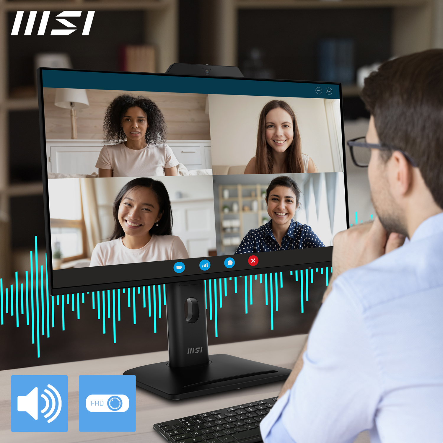Un homme regarde un moniteur affichant un appel vidéo avec quatre femmes. Moniteur MSI avec icônes de son et FHD, et clavier.