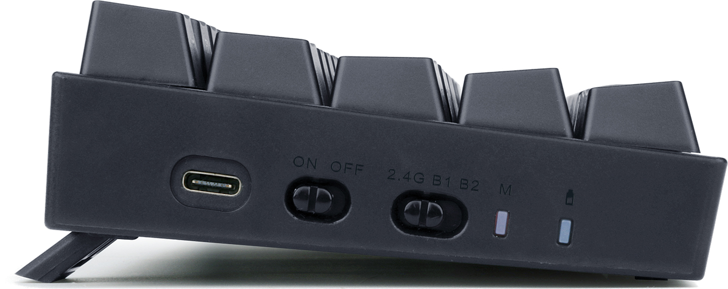 Widok z boku czarnej klawiatury. Posiada port USB-C, przełączniki zasilania i trybów 2.4G i B1/B2. Są diody kontrolne.
