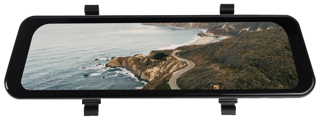 Lusterko samochodowe z widokiem na krajobraz nadmorski. Kręta droga, ocean, klify i niebo są widoczne.