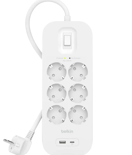 Beyaz Belkin dalgalanma koruyucu, altı priz, bir anahtar ve USB bağlantı noktalarıyla. Bir fiş ve kablo uzanıyor.