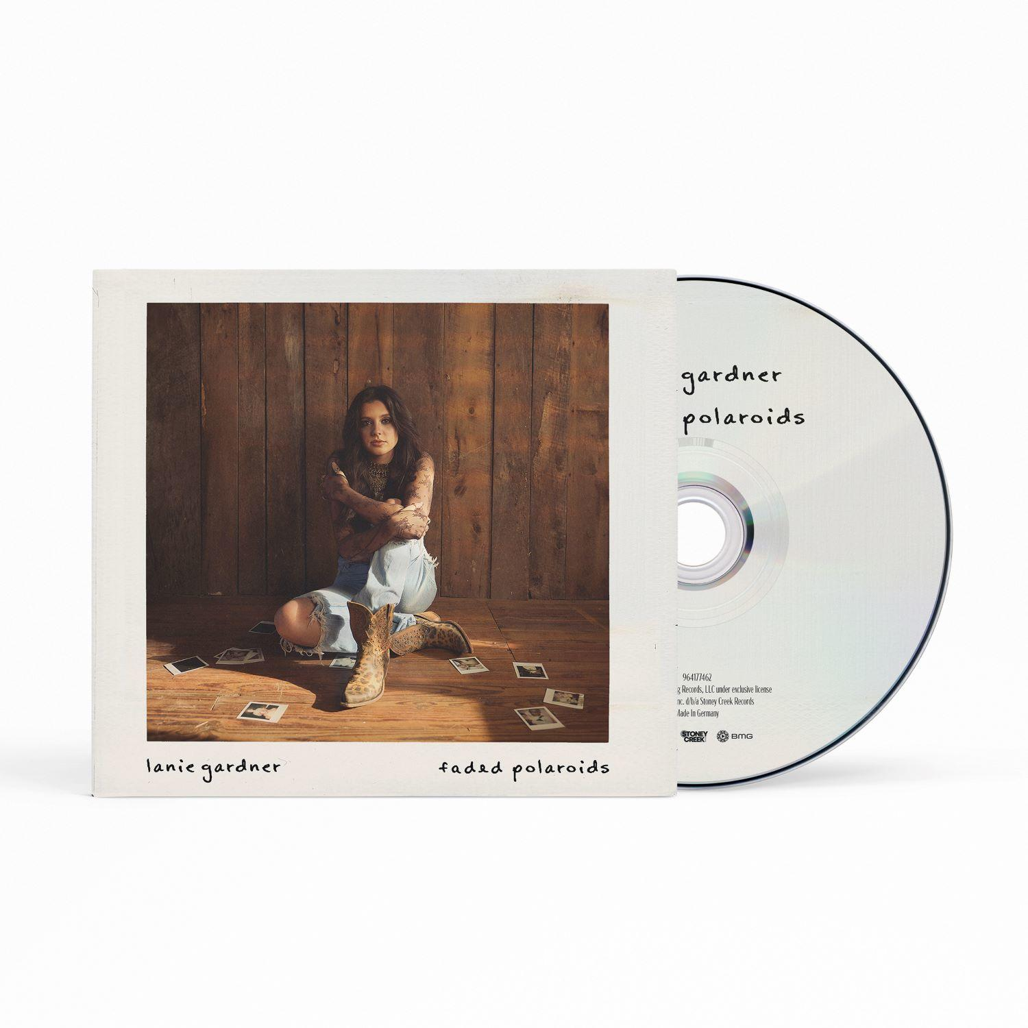CD-Hülle mit Foto einer Frau, die auf einem Holzboden sitzt, umgeben von Polaroids. Daneben liegt eine CD. Der Albumtitel lautet "faded polaroids".