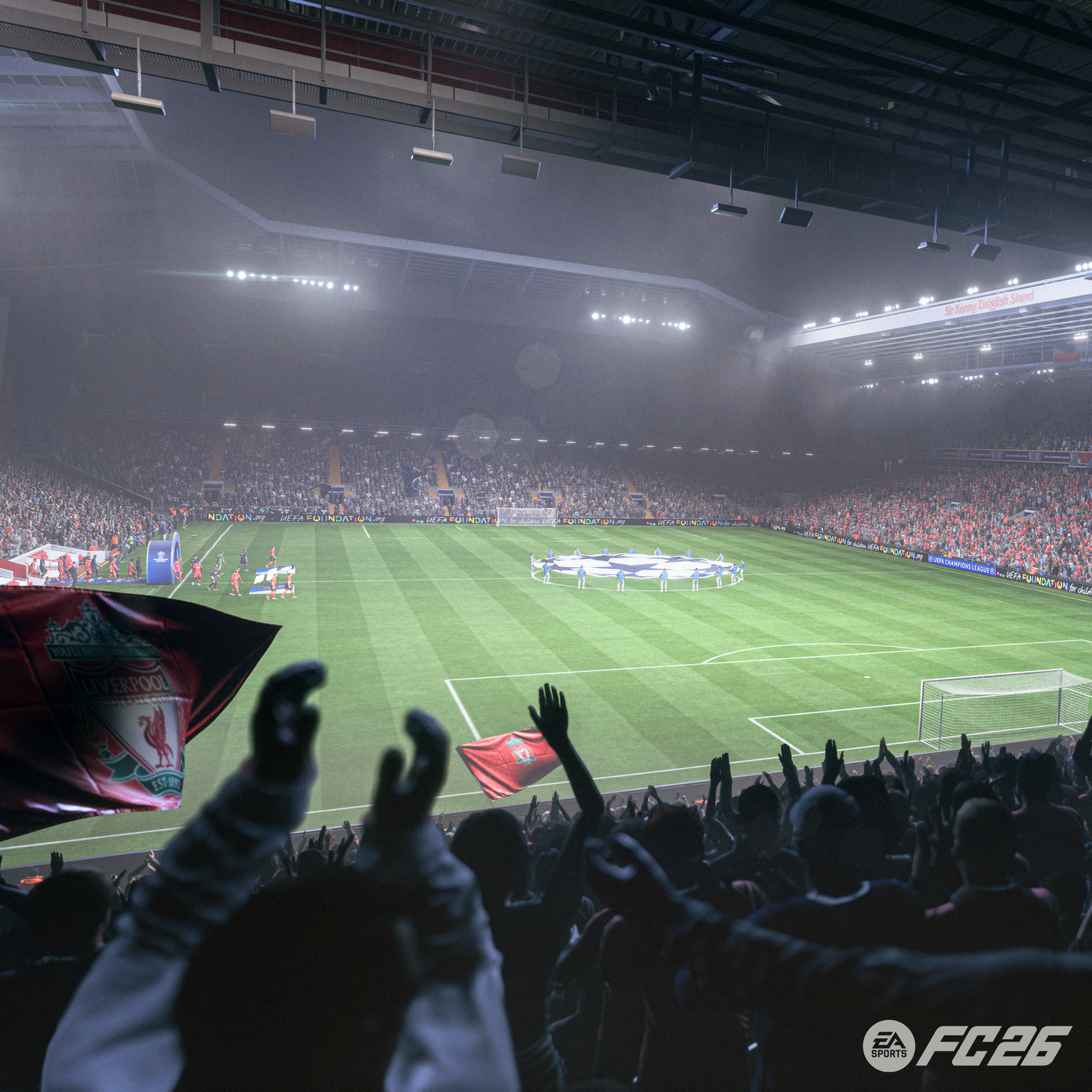 Estadio de fútbol lleno de aficionados. Banderas del Liverpool son visibles. Jugadores en el campo. El cielo está nublado.
