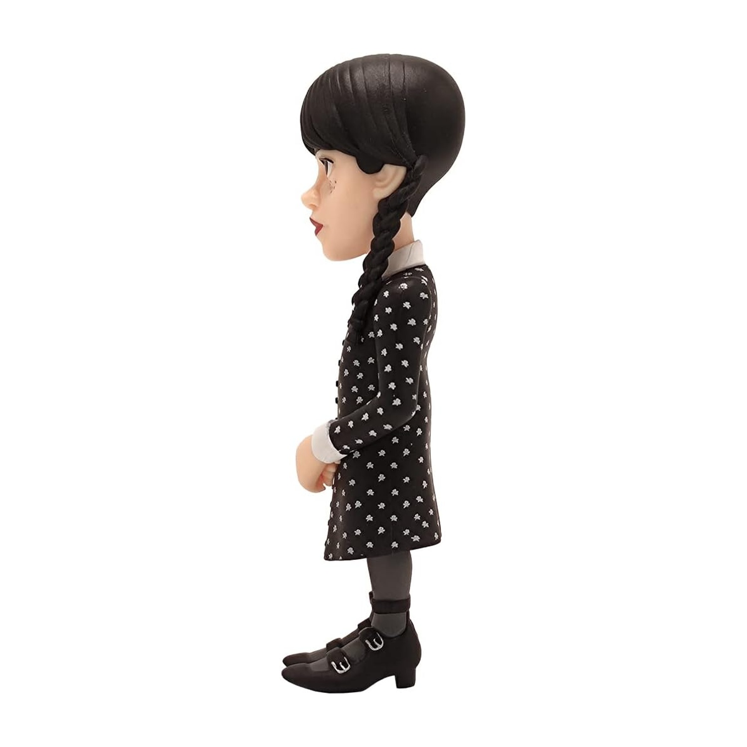 Una statuetta di Mercoledì Addams. Indossa un vestito nero con fiori bianchi, scarpe nere e i suoi capelli in trecce. Lo sfondo è bianco.