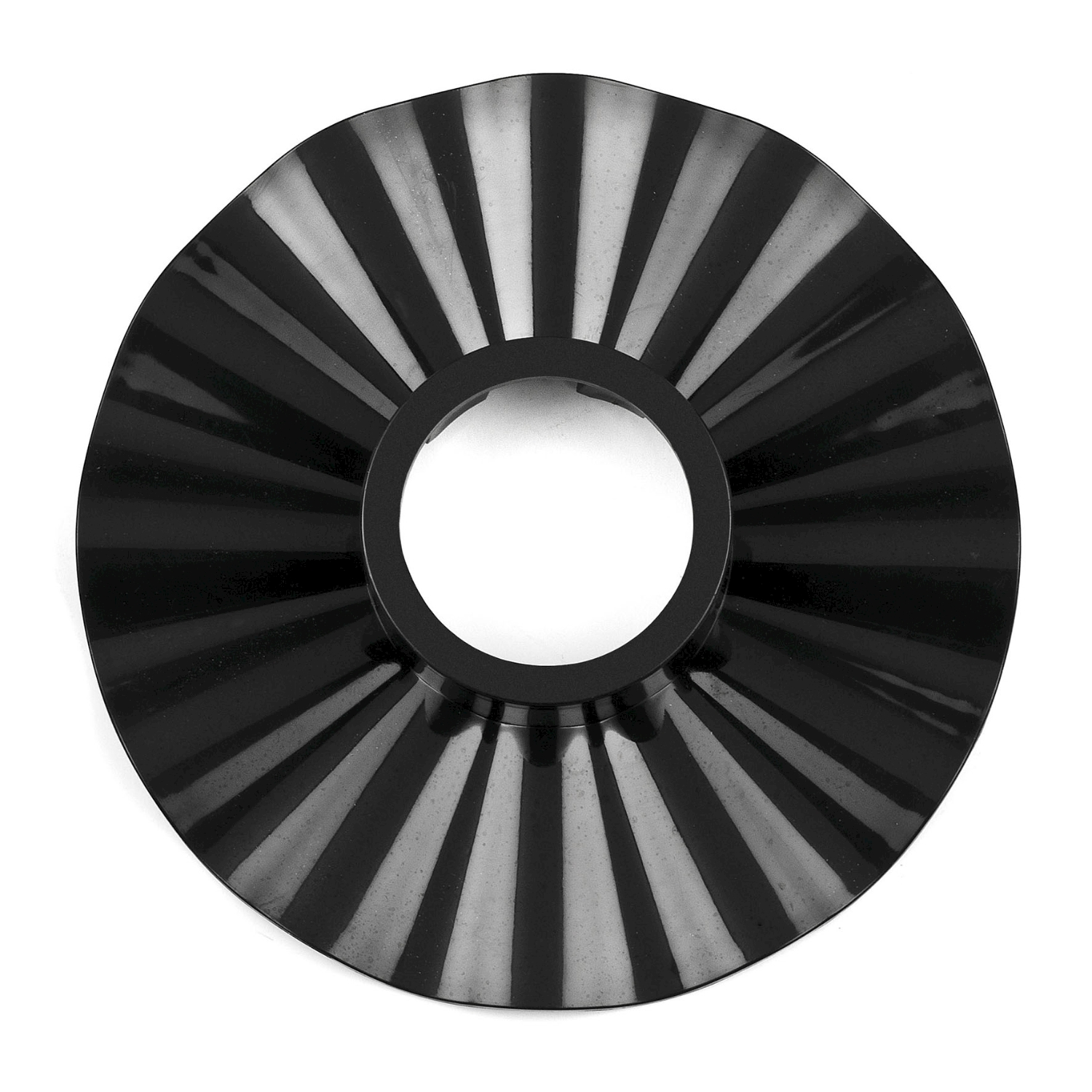 Oggetto di plastica nera con foro centrale e linee radiali, su sfondo bianco.