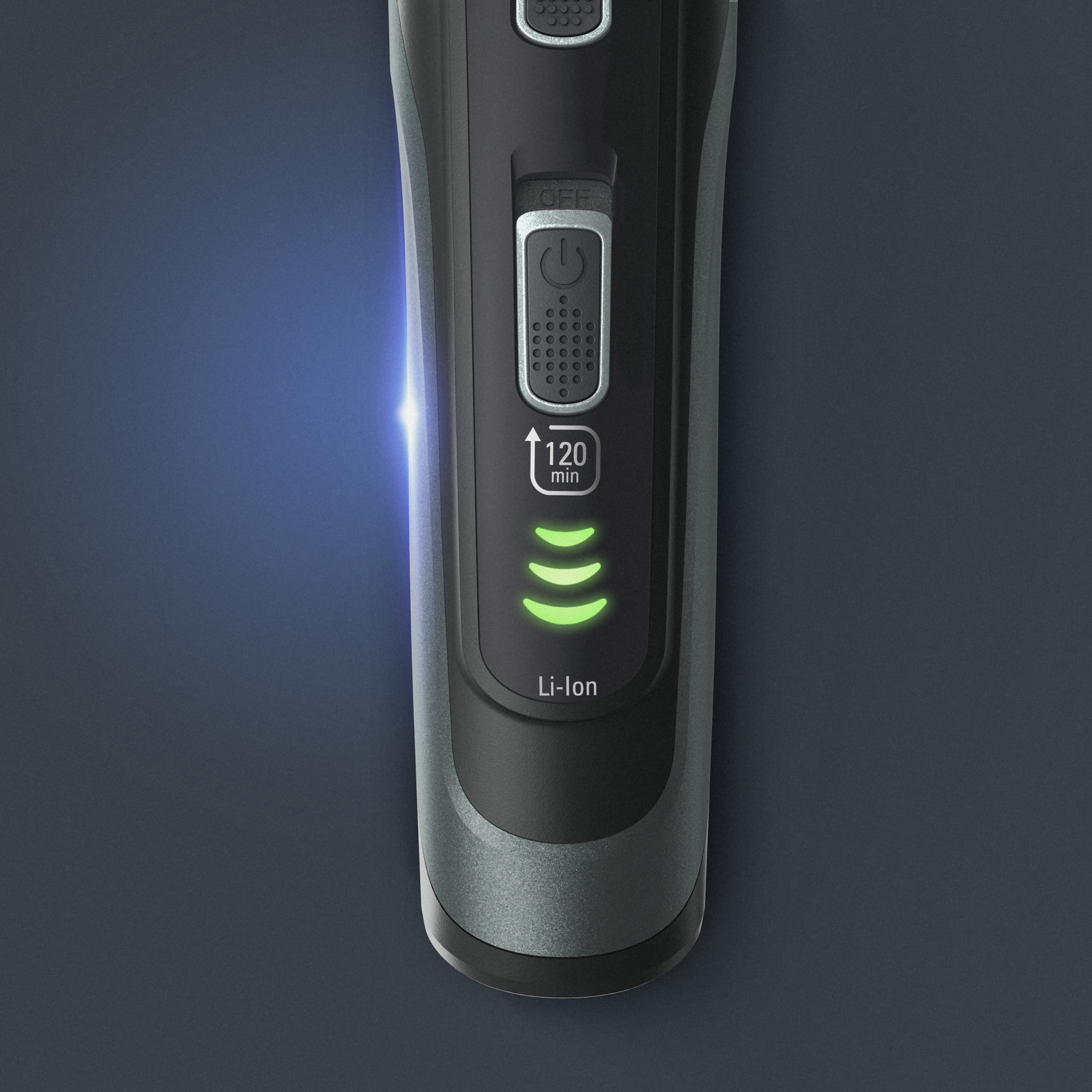 Primer plano de una afeitadora eléctrica negra y gris. Muestra el botón de encendido, el temporizador y el indicador del nivel de batería con luces verdes.