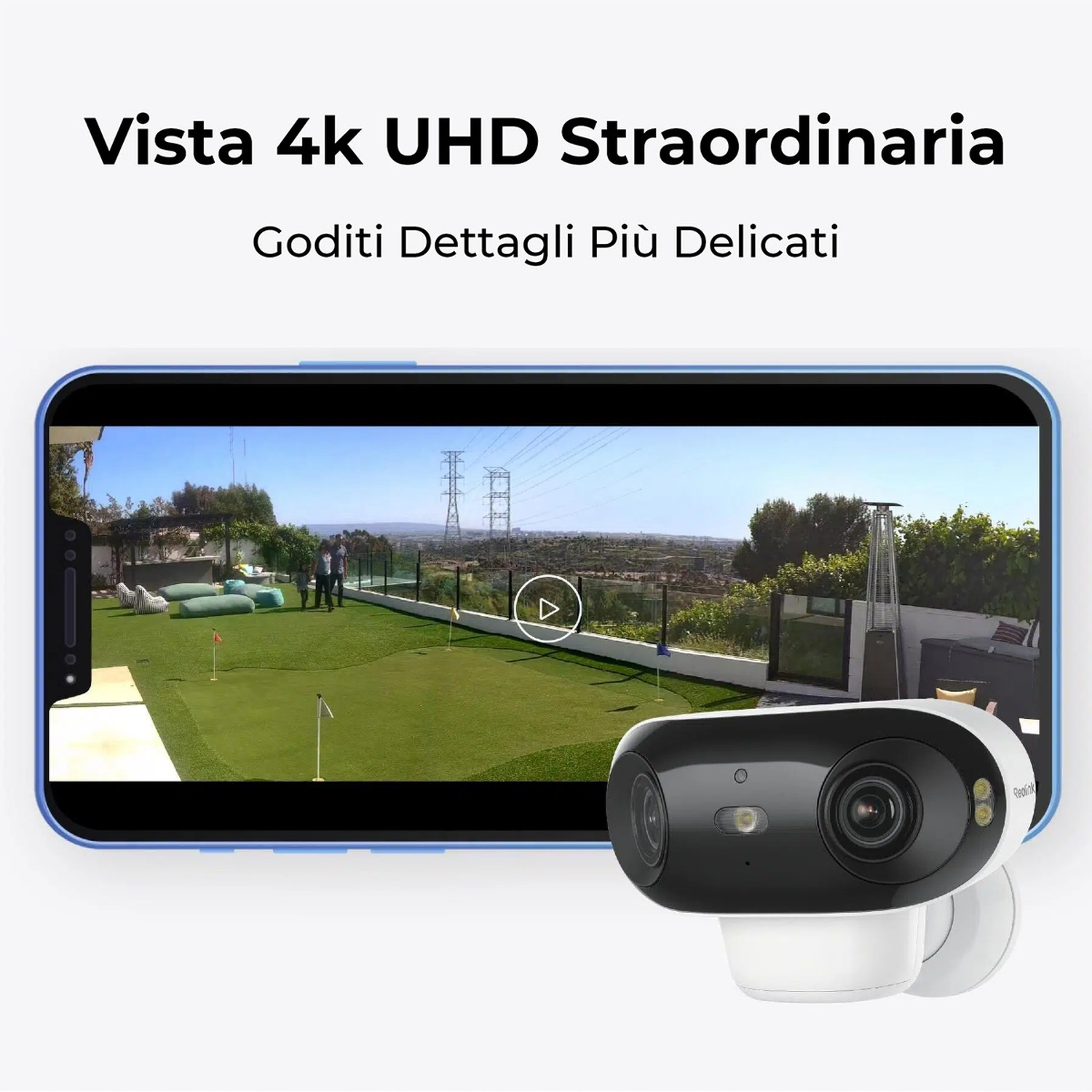 Una telecamera di sicurezza mostra un prato verde con persone. Sullo sfondo ci sono alberi e linee elettriche. La telecamera è in bianco e nero.