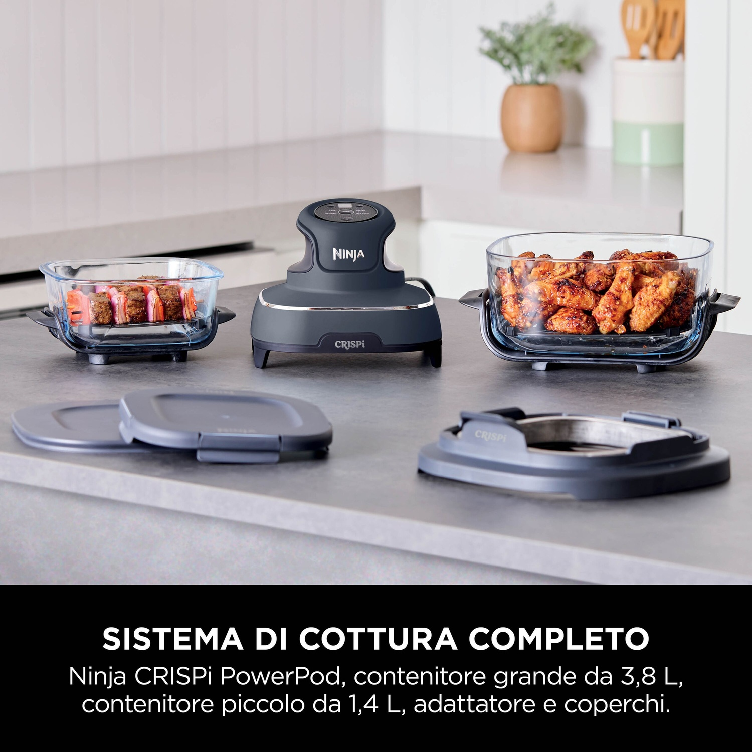 Ninja Crispi PowerPod con due contenitori di vetro con cibo, coperchi e un adattatore su un bancone.