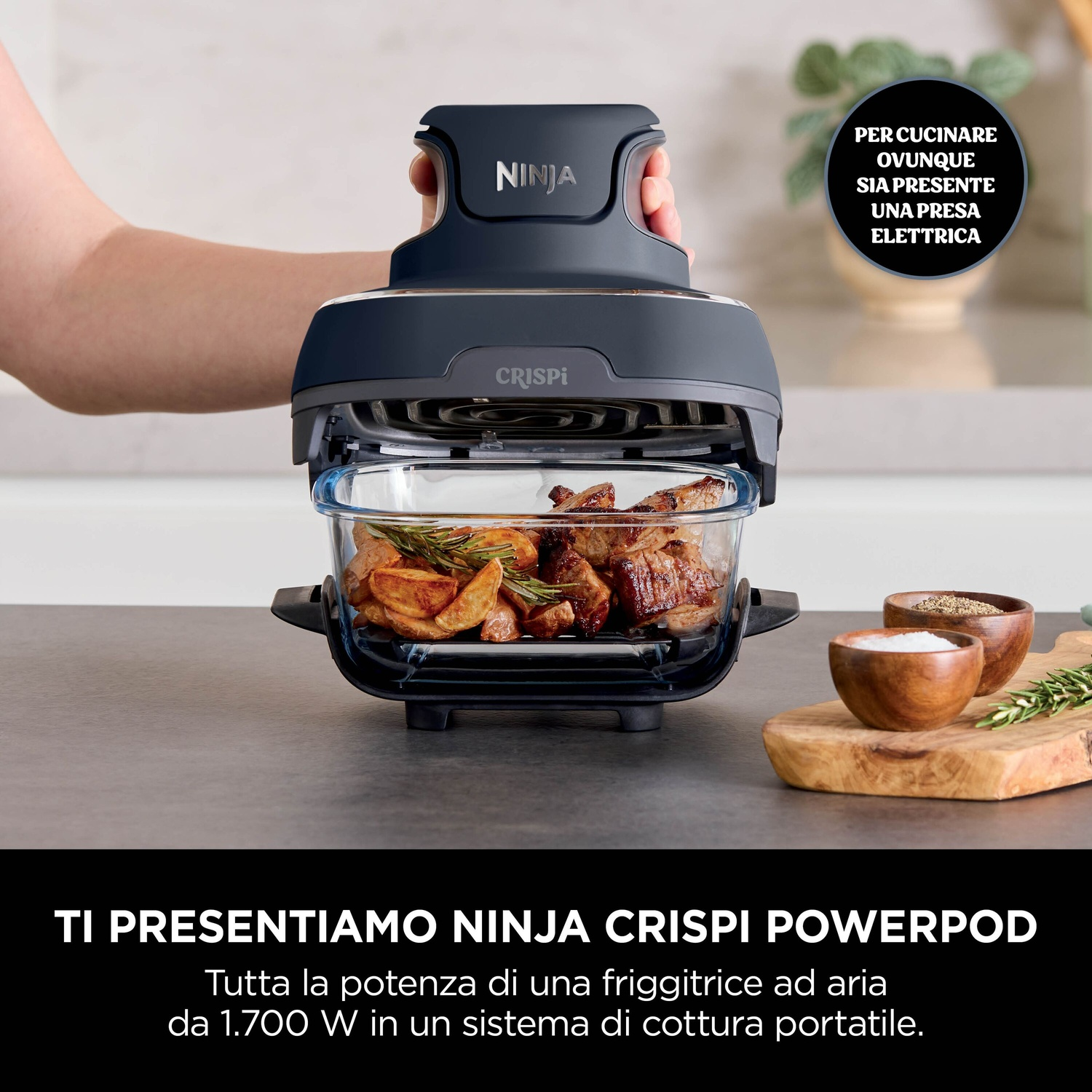 Una friggitrice ad aria con cibo all'interno. Una persona tiene la maniglia. C'è del testo sull'immagine.