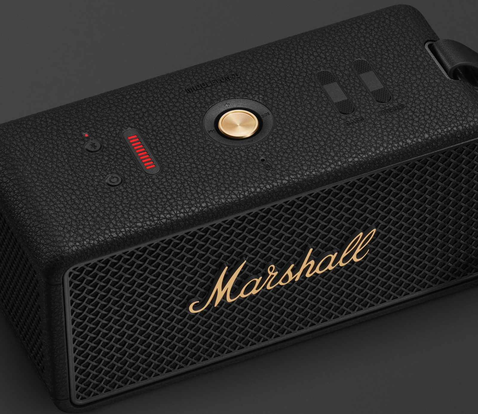 Altoparlante Marshall nero con dettagli dorati. Frontale a rete, manopole e indicatore batteria. Texture in pelle.