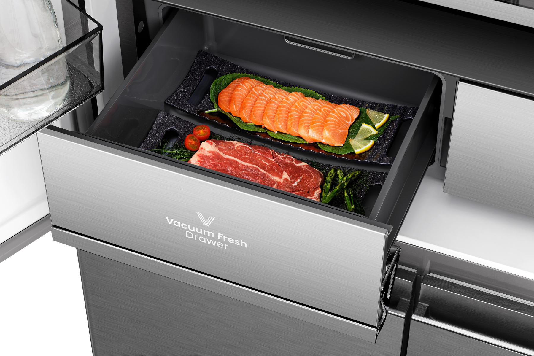 Eine Kühlschublade mit Lachs, Steak, Gemüse und Zitronen. Die Schublade ist mit 'Vacuum Fresh Drawer' beschriftet.