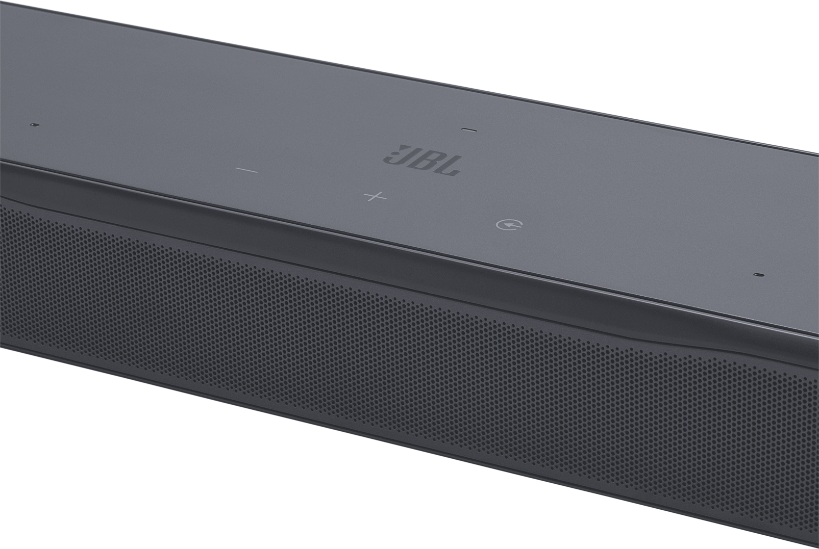 Közelkép egy sötétszürke JBL soundbarról. Perforált hangszóró rács és vezérlőgombok vannak rajta. A márkalogó látható.