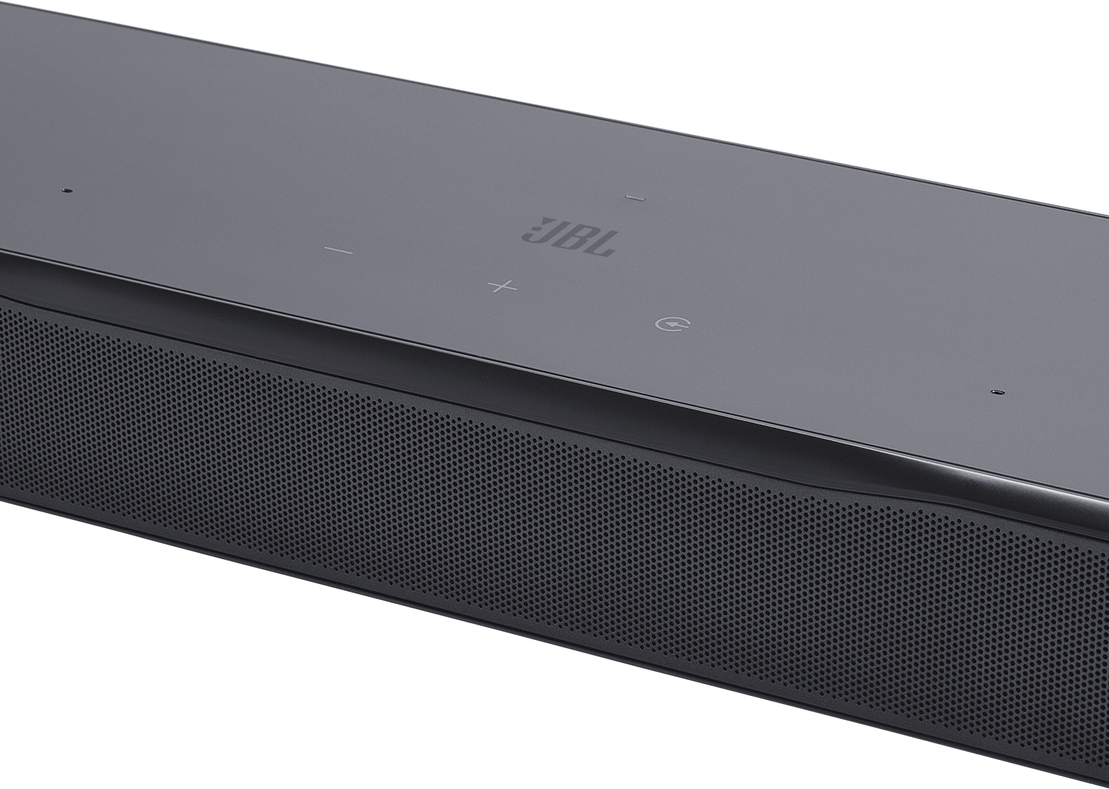Egy sötétszürke JBL soundbar. Perforált előlapja, vezérlőgombjai és a JBL logója van. A háttér fekete.