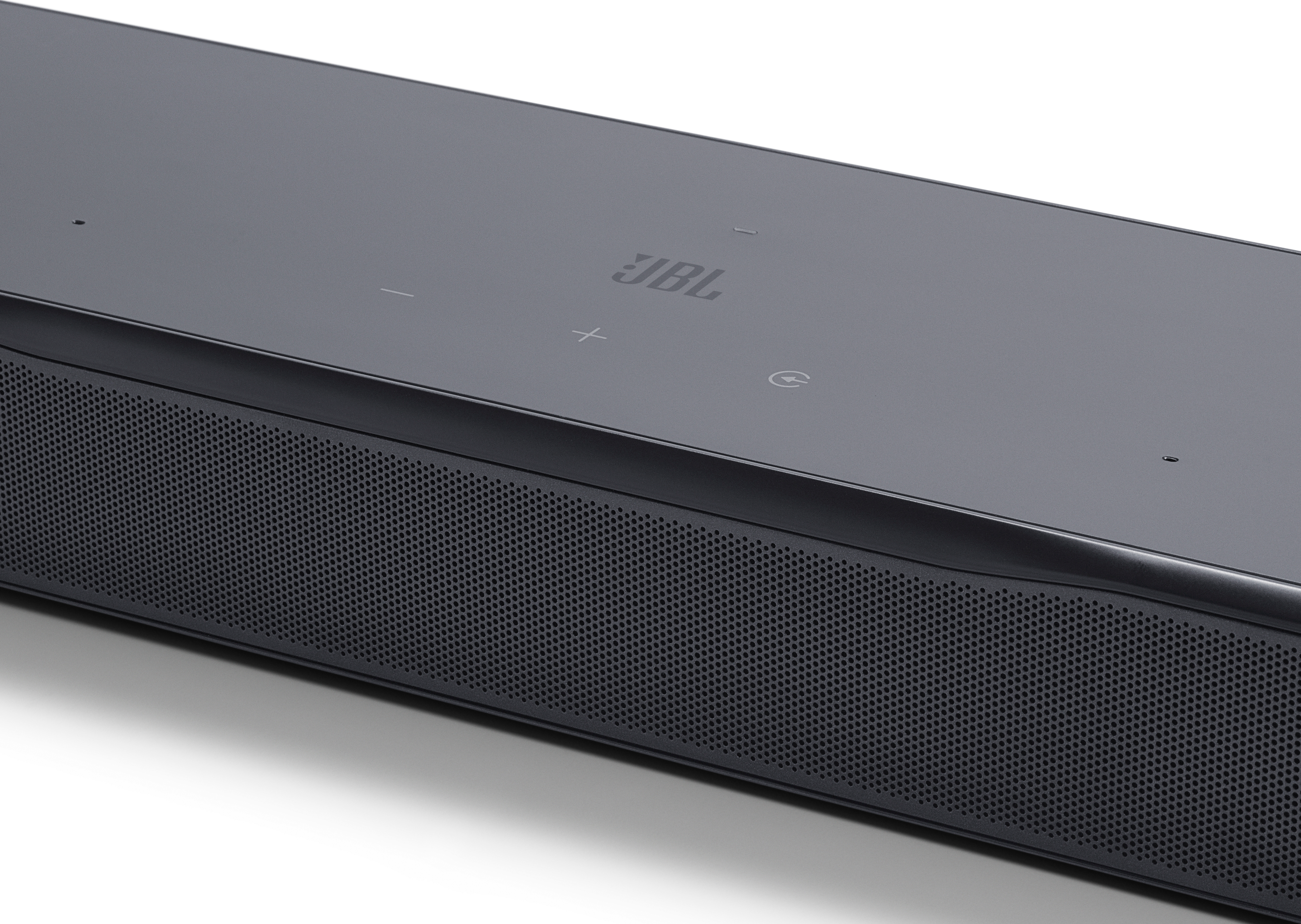 Eine schwarze JBL-Soundbar. Sie hat Lautstärke- und Einschalttasten sowie das JBL-Logo. Die Vorderseite hat eine perforierte Lautsprecherabdeckung.