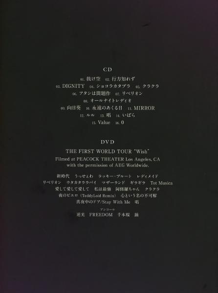 Eine schwarze Seite mit japanischem Text. Listet eine CD- und DVD-Titelliste auf, einschließlich Songtiteln und Tournee-Details.