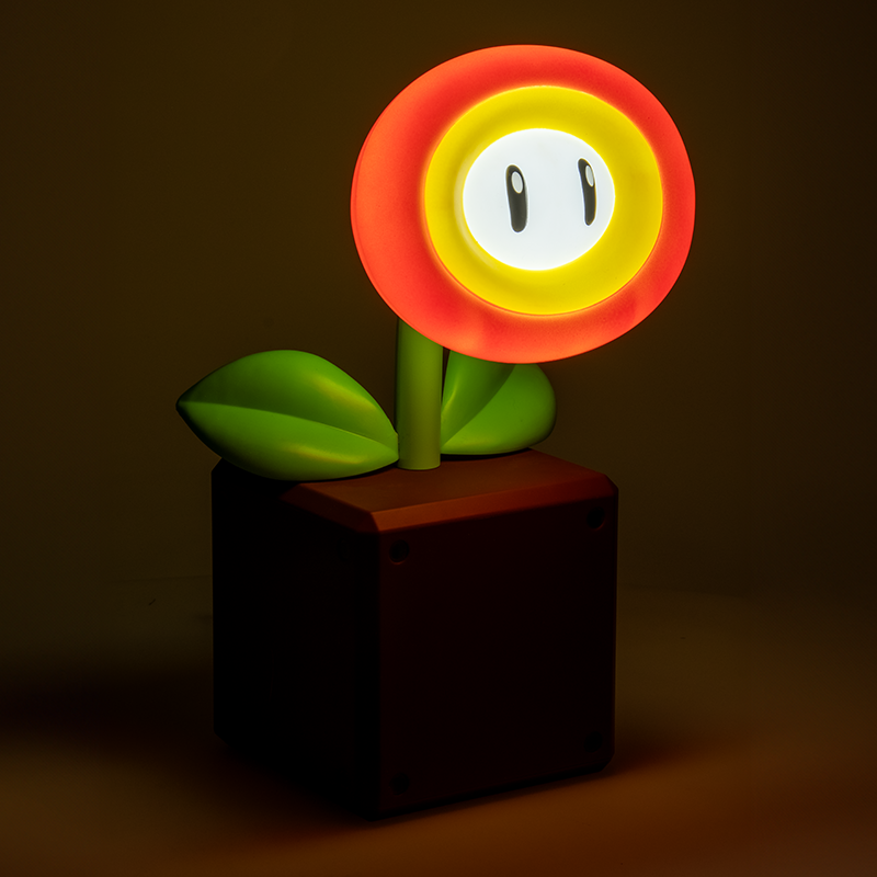 Eine Mario Piranha-Pflanzenlampe. Sie hat einen rot-gelben Blumenkopf mit Augen, grüne Blätter und einen braunen Topf.