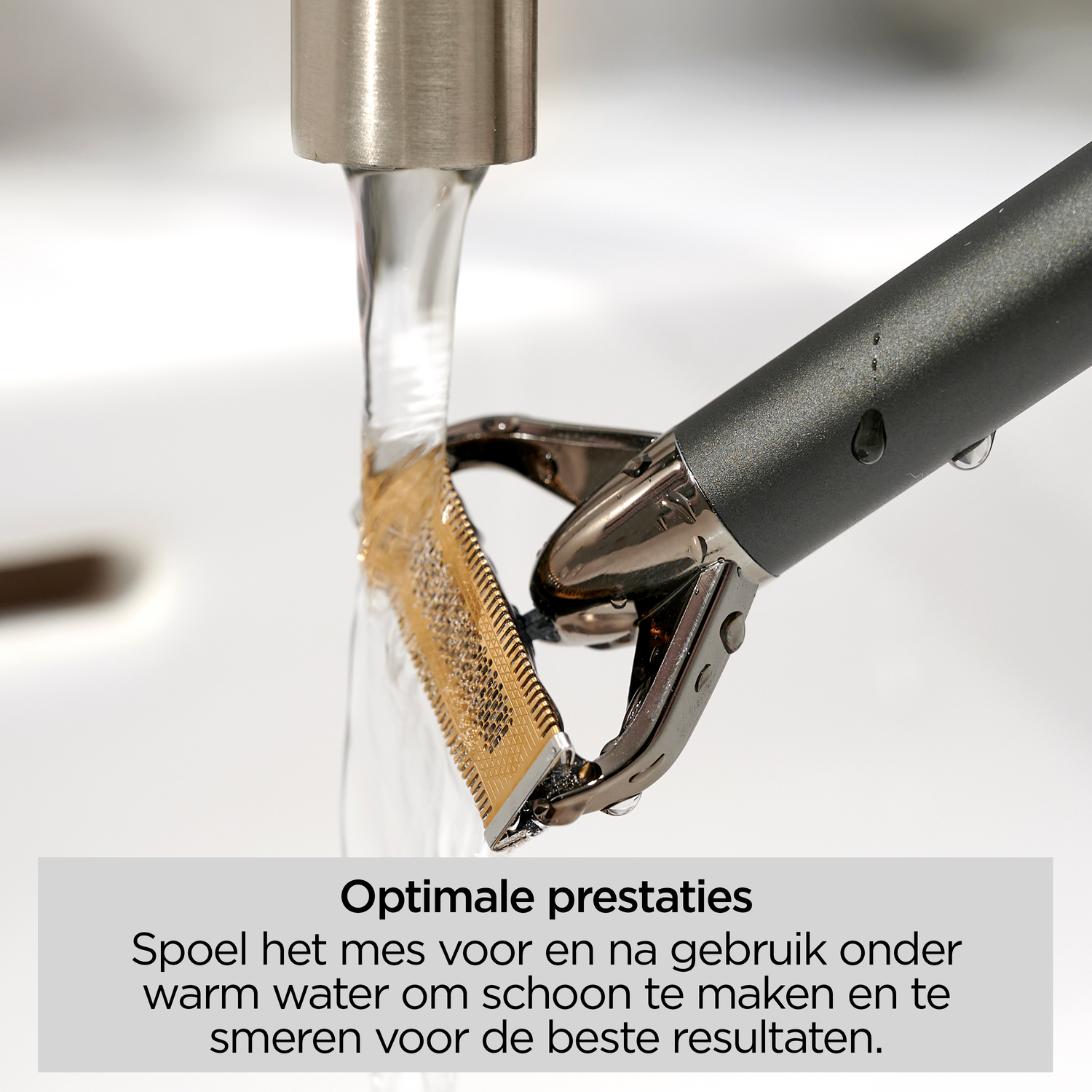 A razor blade is rinsed under water. The razor is black and silver. The blade is gold. The background is white.