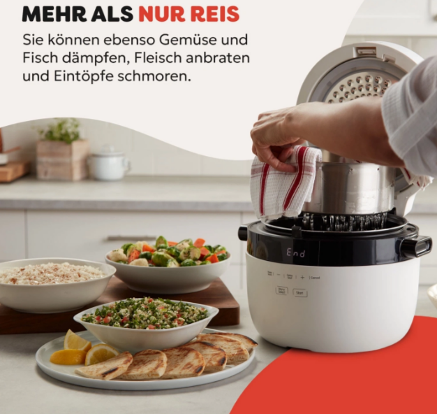 Eine Person entfernt einen Topf aus einem Reiskocher. Auf einem Tisch stehen Schüsseln mit Essen wie Reis, Gemüse und Brot.