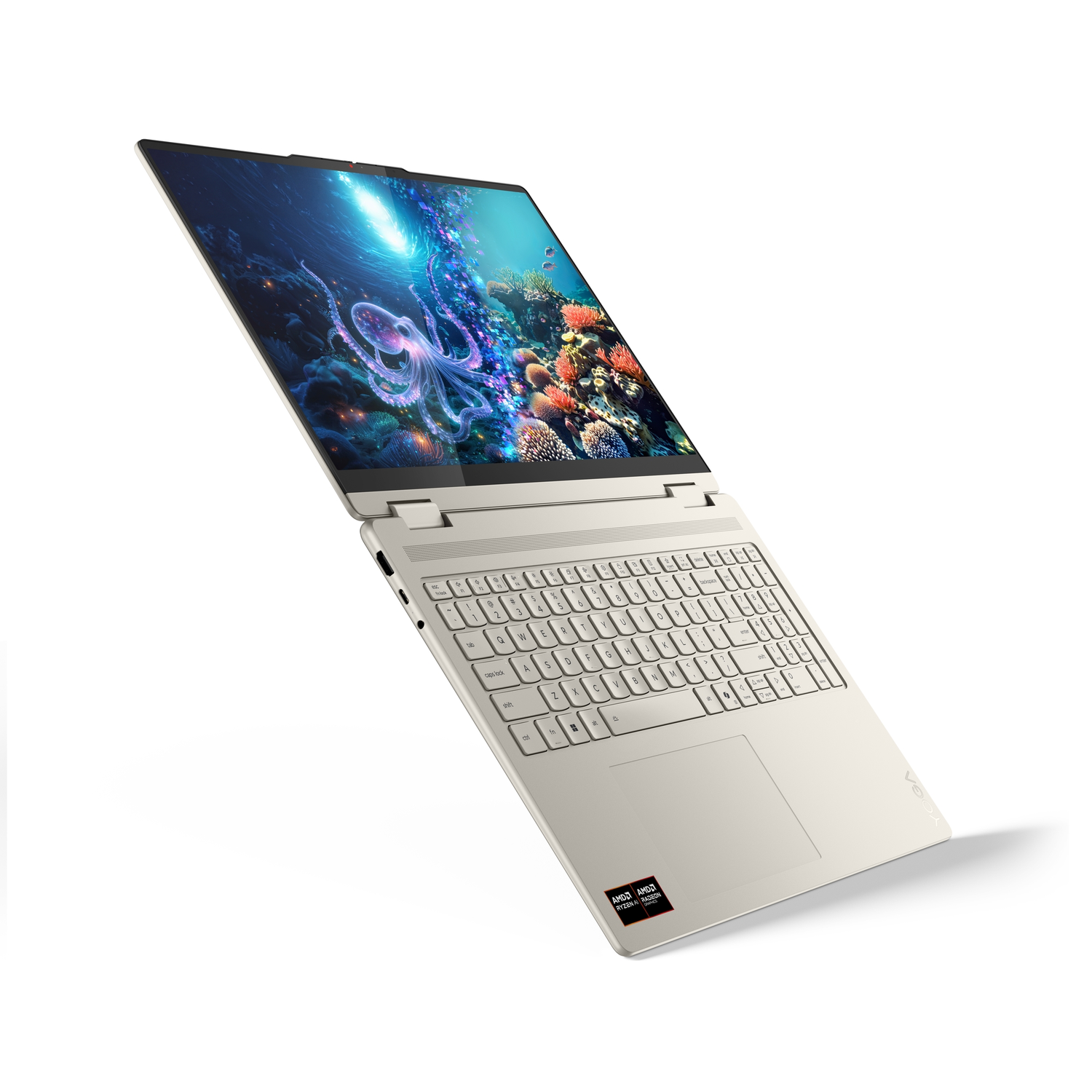 Beige laptop with screen showing underwater scene with octopus. Keyboard visible. AMD and Radeon stickers. White background.