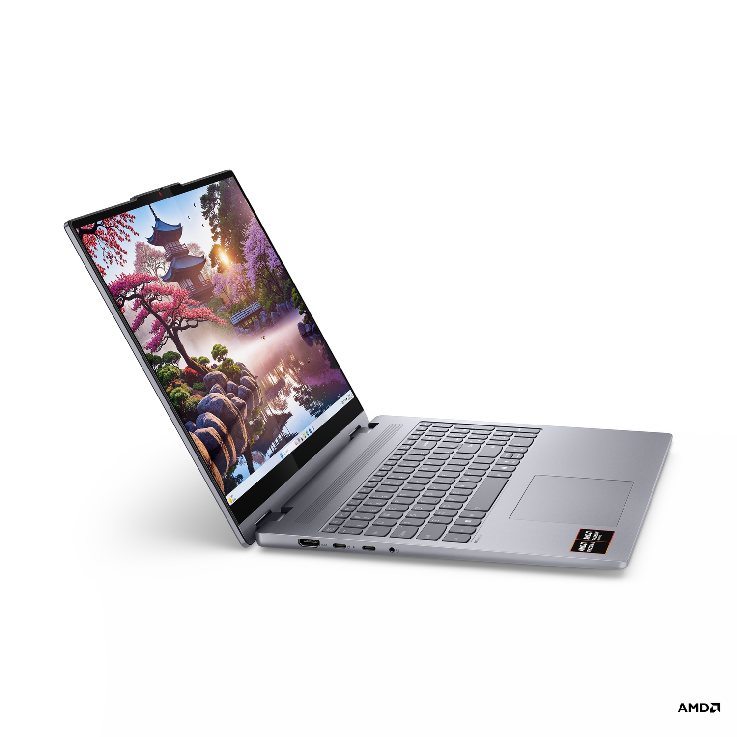Een zilveren laptop is opengeklapt en toont een Japans landschap. Het toetsenbord is zichtbaar. Het AMD-logo staat rechtsonder.