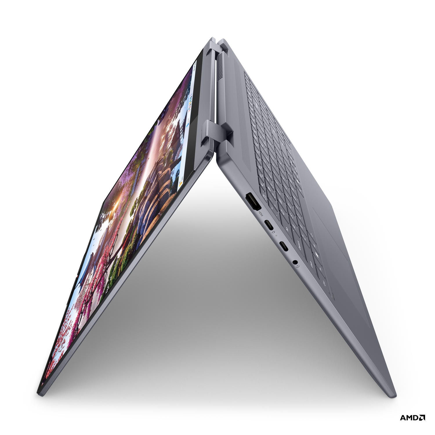 Een grijze laptop is open. Het scherm toont een kleurrijk landschap. Het toetsenbord is zichtbaar. De laptop staat op een witte ondergrond.