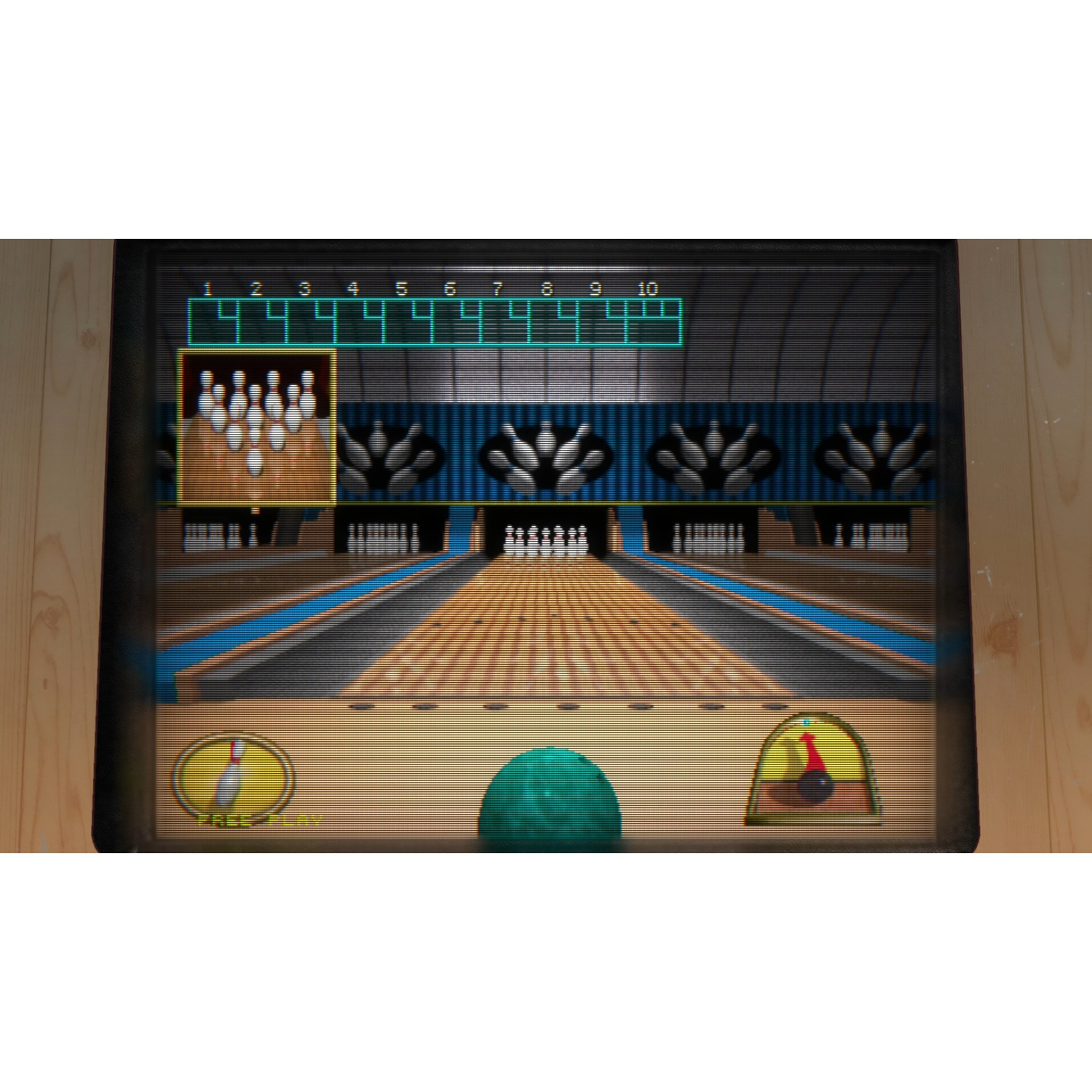 Een bowlingbaan-scène weergegeven op een scherm. Pinnen, een bowlingbal en een scoreweergave zijn zichtbaar. Het scherm is omlijst door hout.