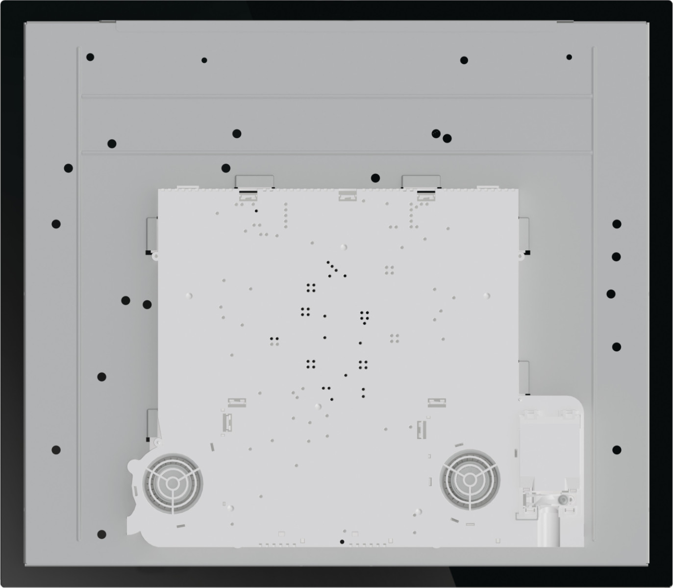 Widok z góry na biało-szarą płytę indukcyjną. Czarne kropki rozrzucone. Widoczne dwa elementy w kształcie wentylatora.