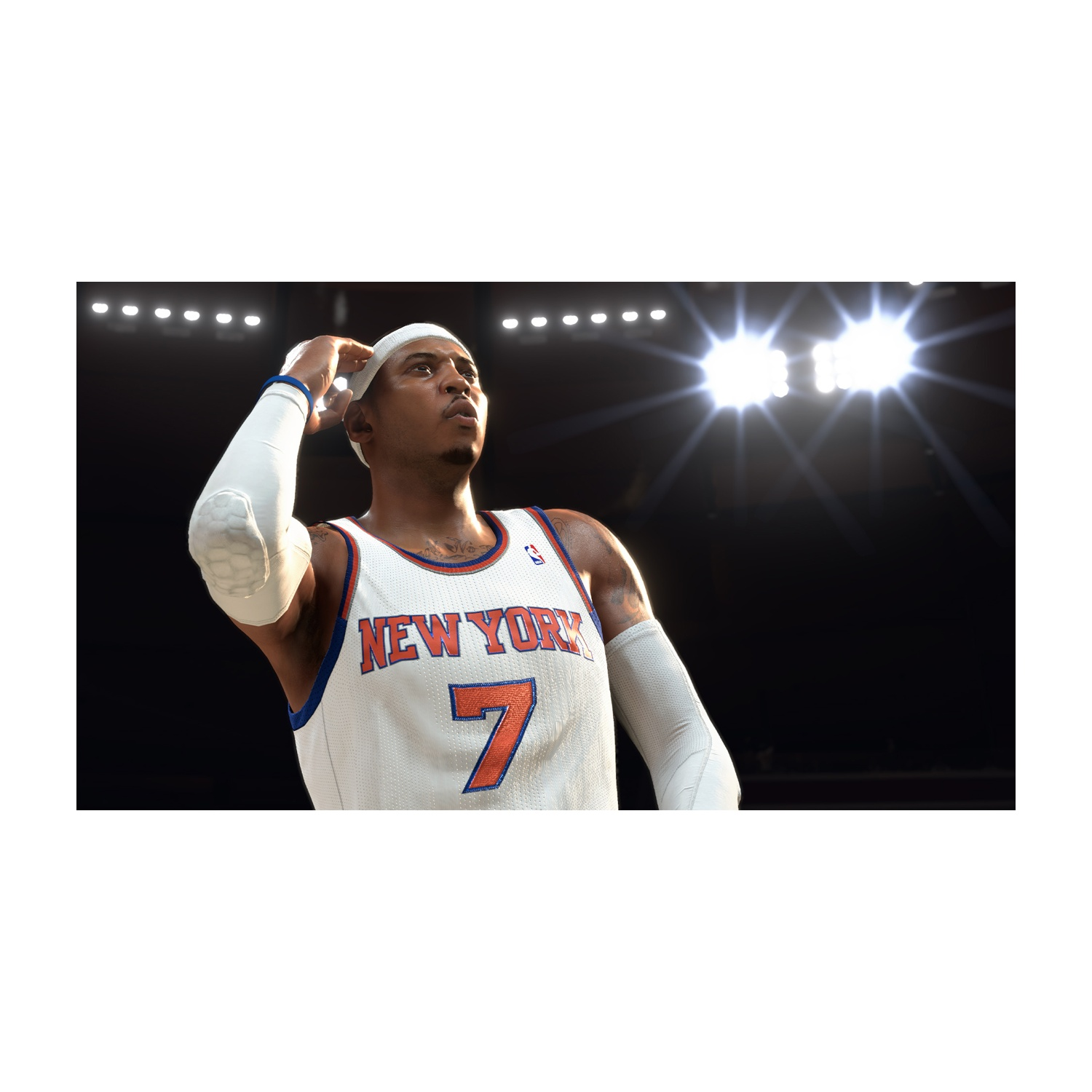 Un giocatore di basket con la maglia dei New York Knicks guarda in alto. Ha una fascia bianca e maniche sulle braccia. Lo sfondo è scuro con luci.