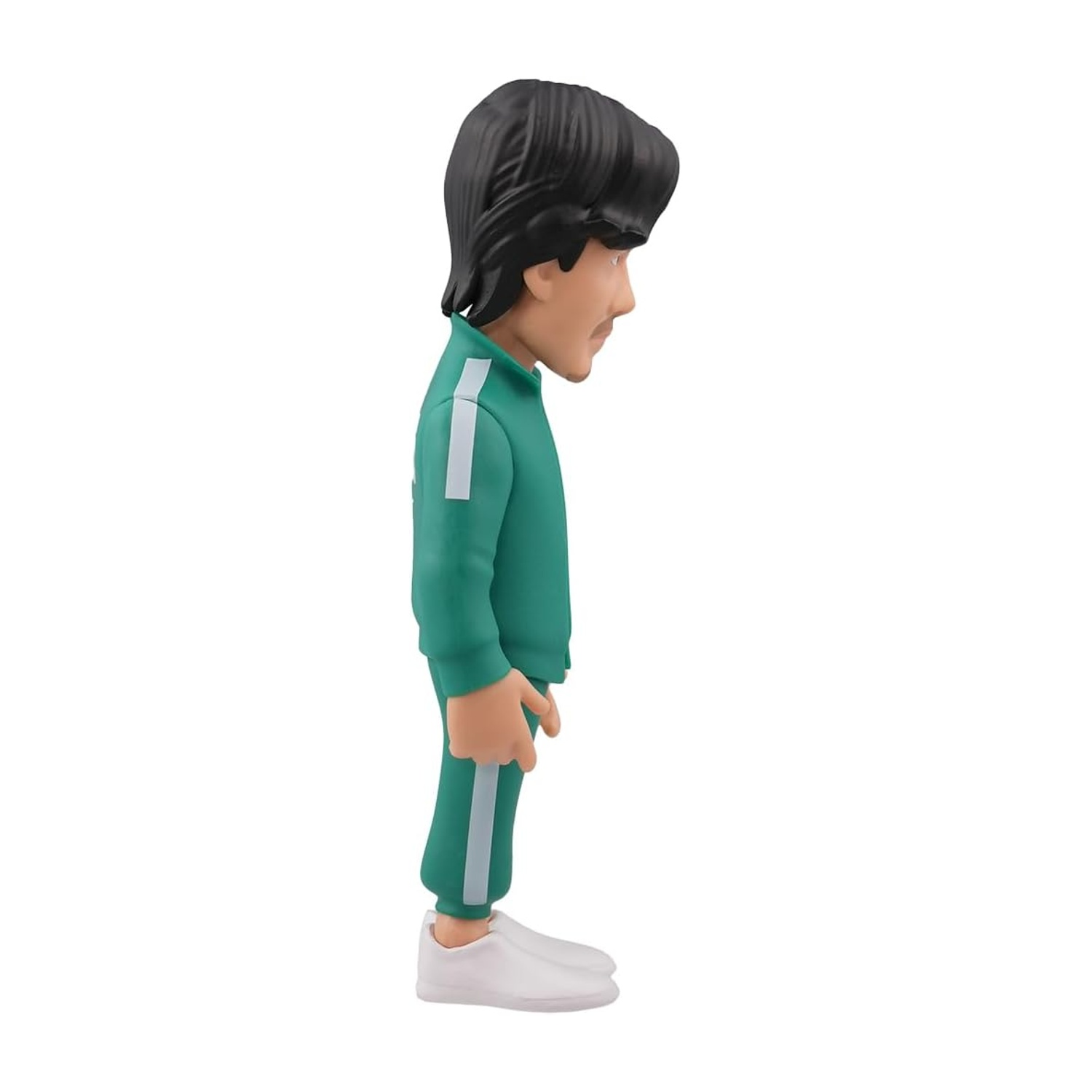 Una statuetta di un uomo in tuta verde con strisce bianche. Ha i capelli neri e indossa scarpe bianche. Lo sfondo è bianco.
