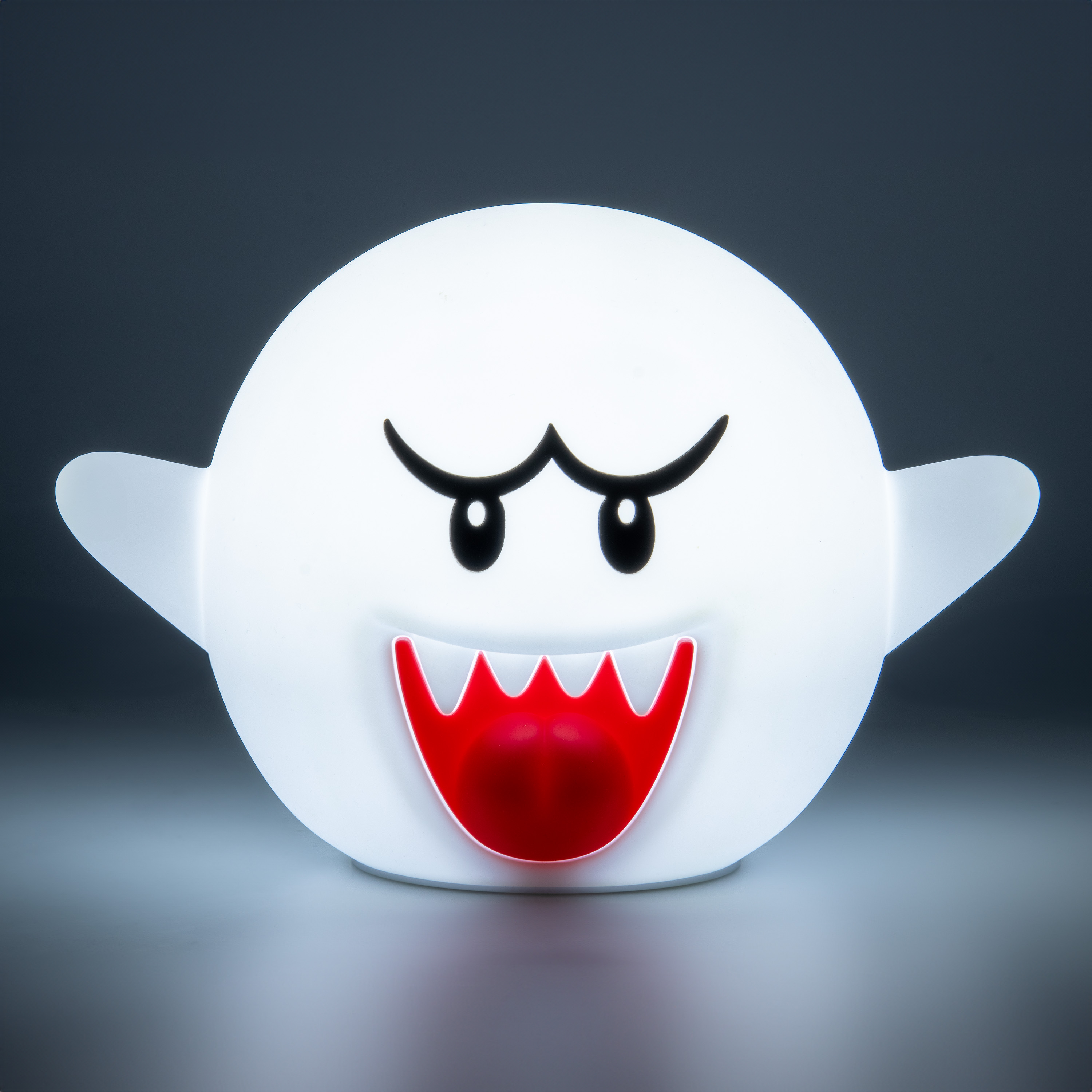 Eine weiße, geisterförmige Lampe mit schwarzen Augen und Augenbrauen sowie einem roten Mund. Es hat zwei kleine Flügel.