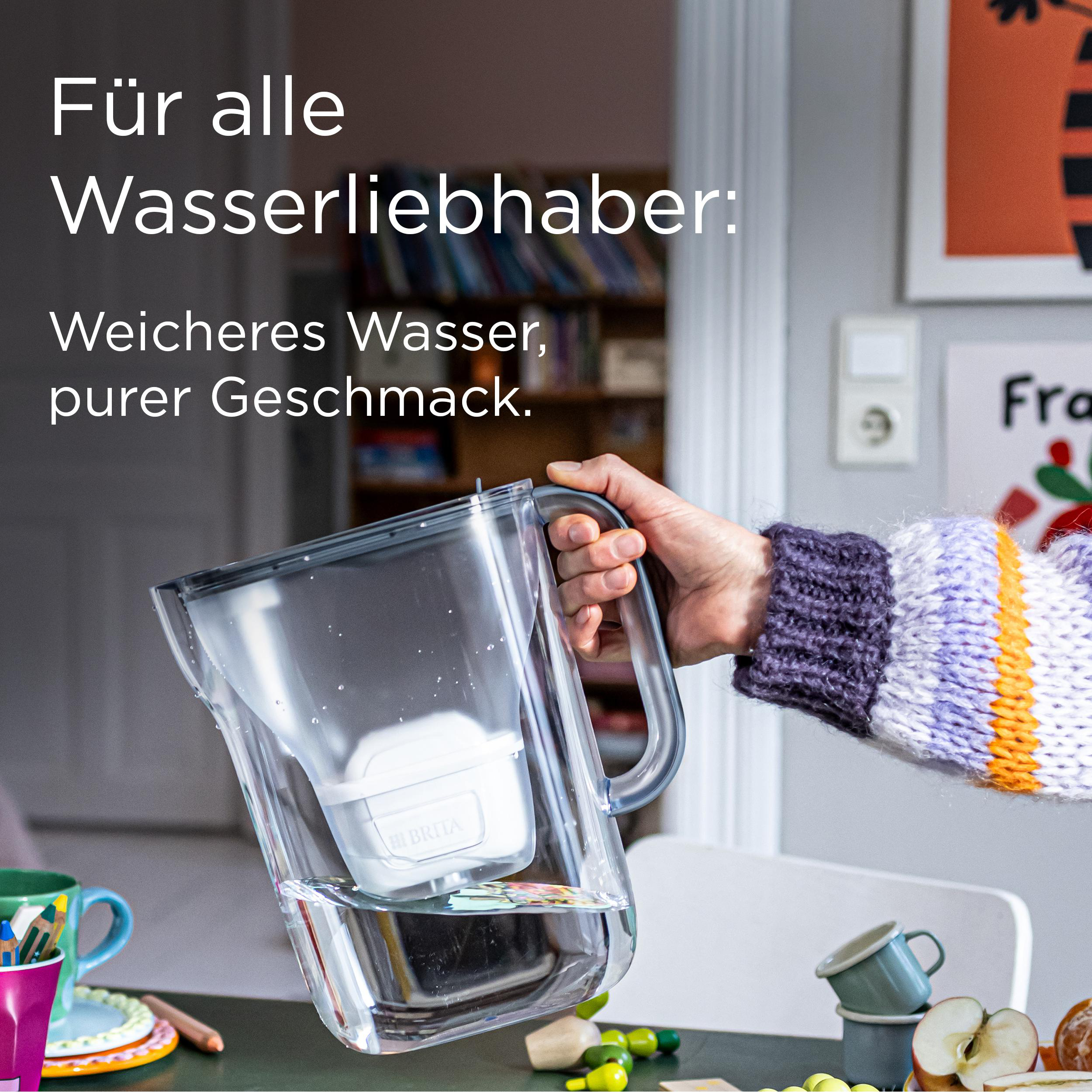 Eine Person hält einen Wasserfilterkrug. Text: Für Wasserliebhaber. Weicheres Wasser, reiner Geschmack.