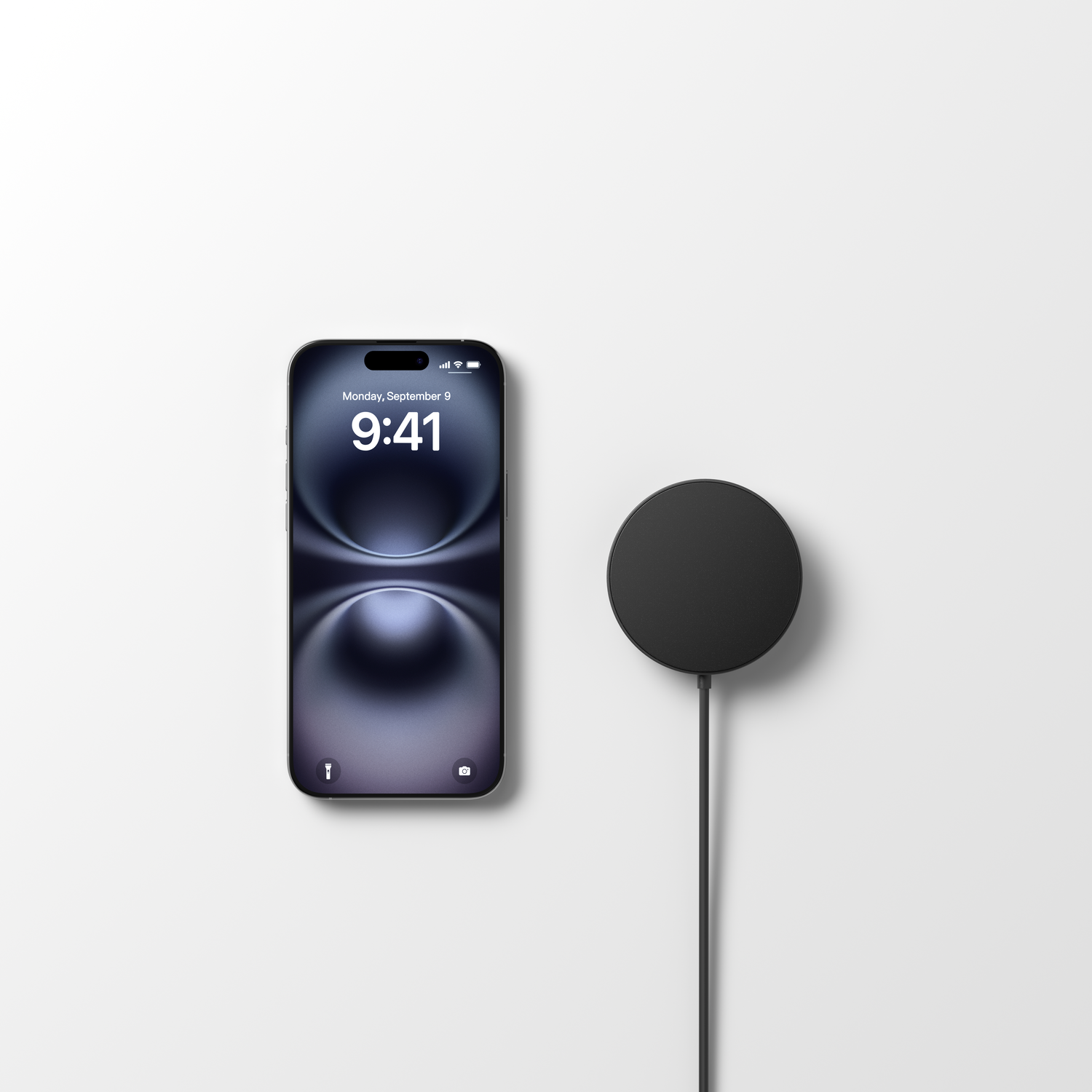 Un iPhone affiche 9h41 le lundi 9 septembre. Un chargeur circulaire noir est à droite, relié par un câble noir. Le tout sur fond blanc.