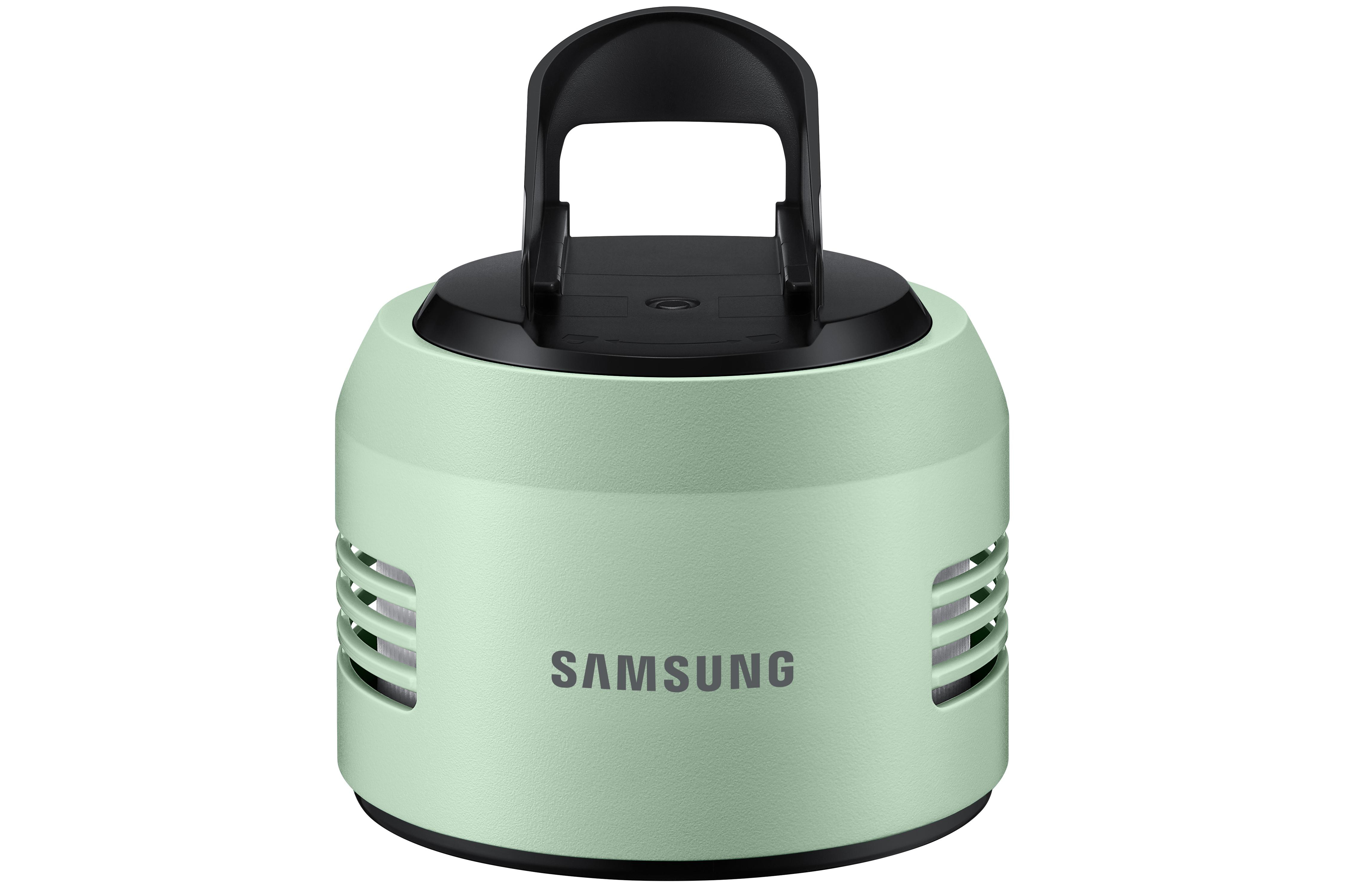 Ein mintgrüner Samsung-Lautsprecher mit schwarzem Griff. Er hat horizontale Lüftungsschlitze und das Samsung-Logo.