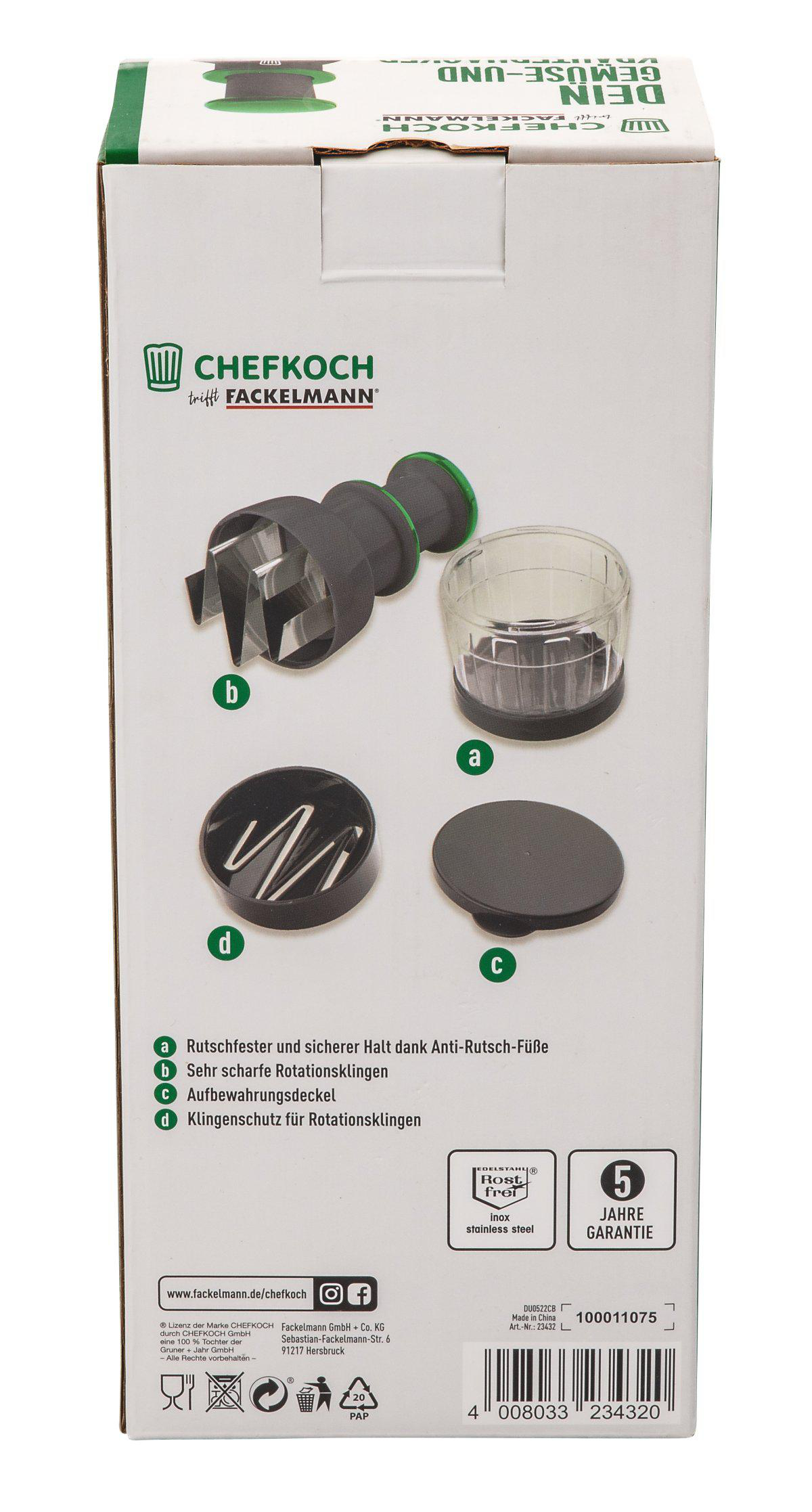 Eine Box mit einem Chefkoch-Gemüseschneider wird gezeigt. Auf der Box sind der Schneider, der Deckel und der Klingenschutz abgebildet. Text und Logos sind ebenfalls auf der Box.