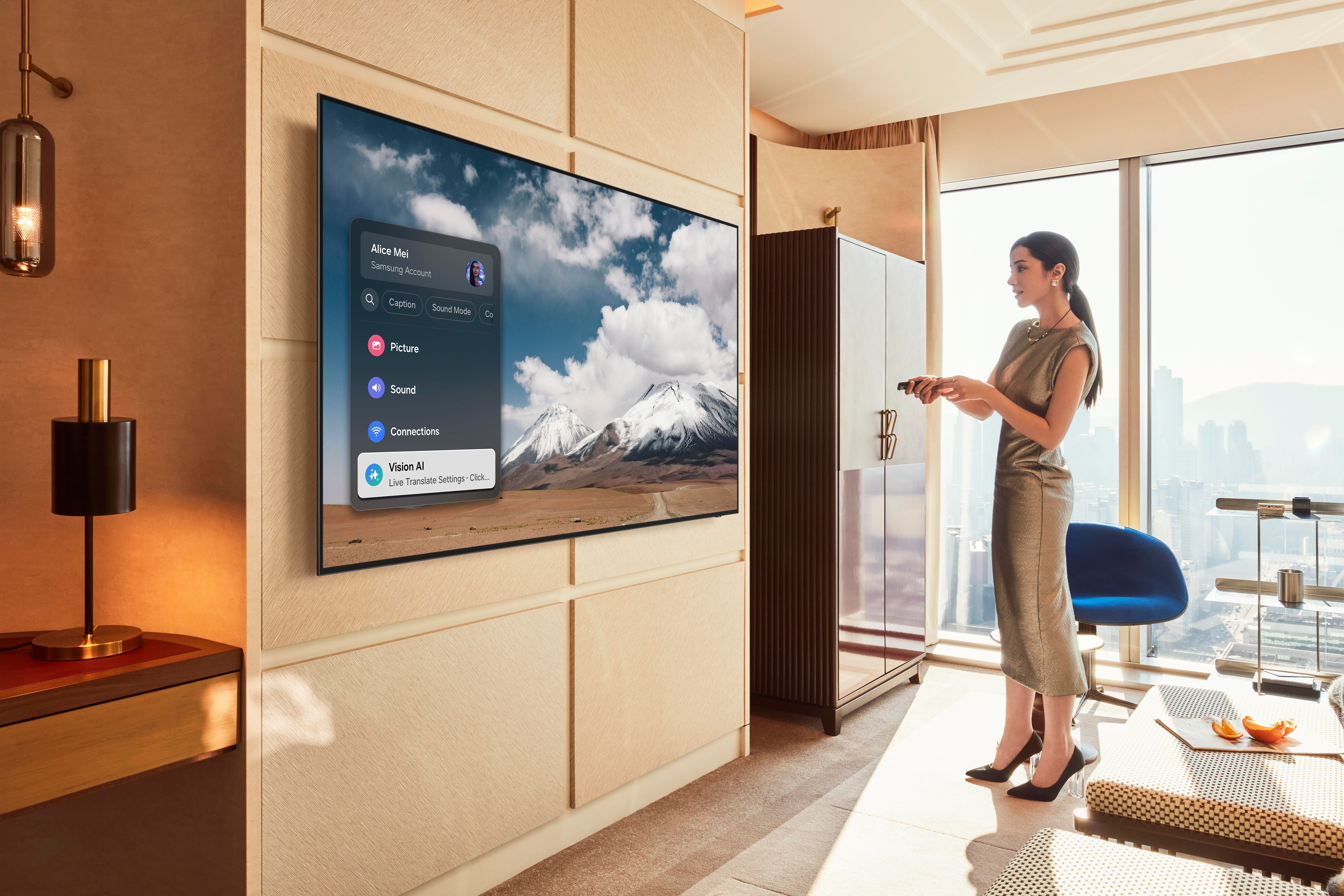 Eine Frau in einem goldenen Kleid steht in der Nähe eines Fernsehers, der eine Berglandschaft zeigt. Sie hält eine Fernbedienung.